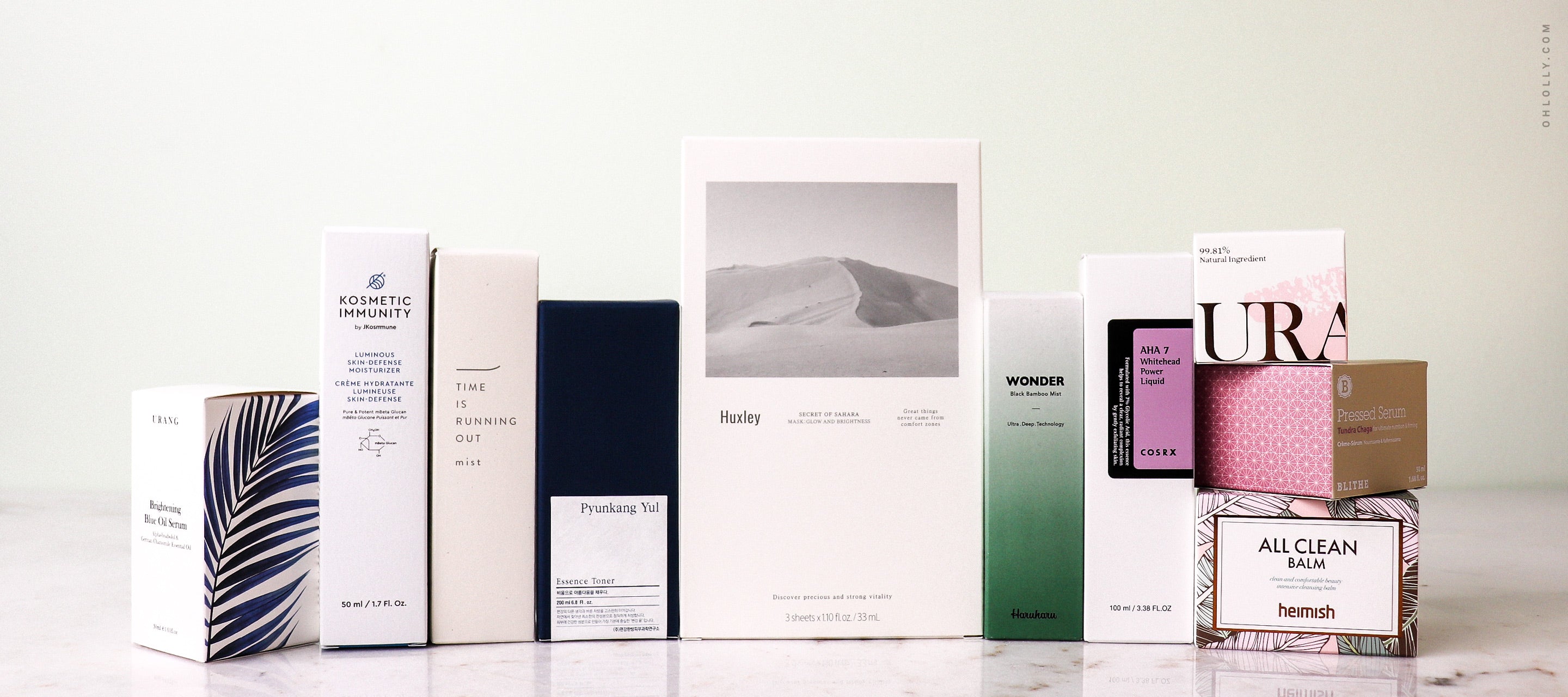 A row of K-Beauty product boxes: Heimish All Clean Balm, Huxley mask, Haruharu Wonder, and URANG serum. Skincare haul.