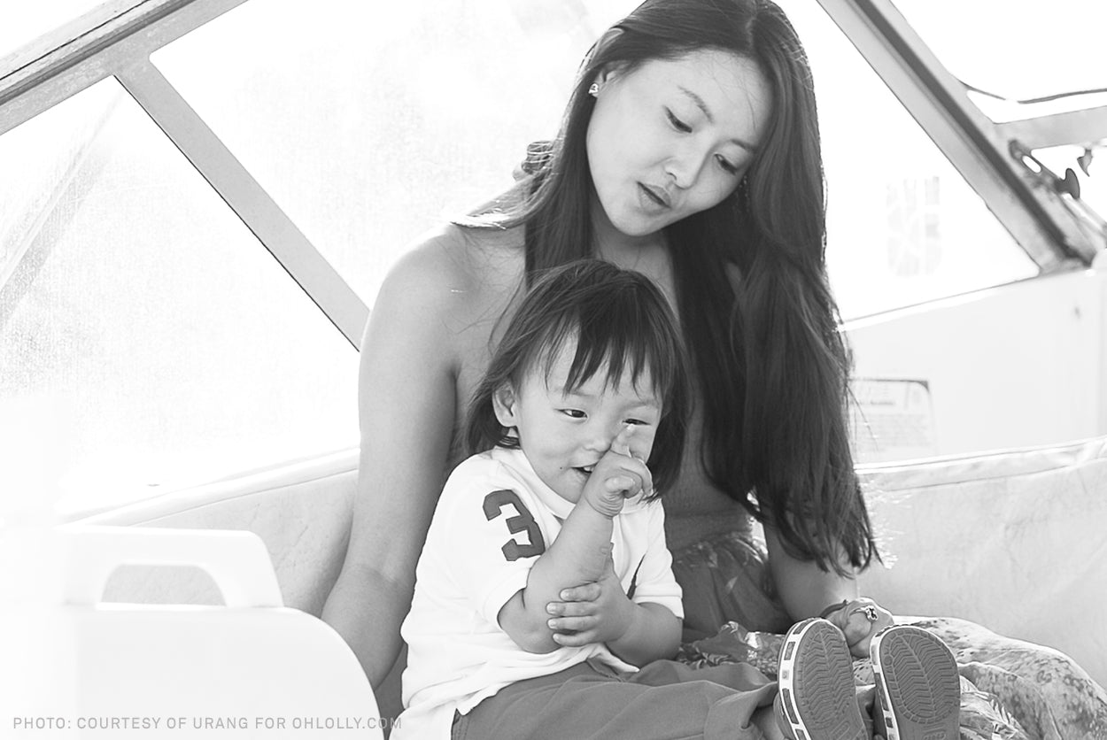 A black and white photo of a woman holding a baby.