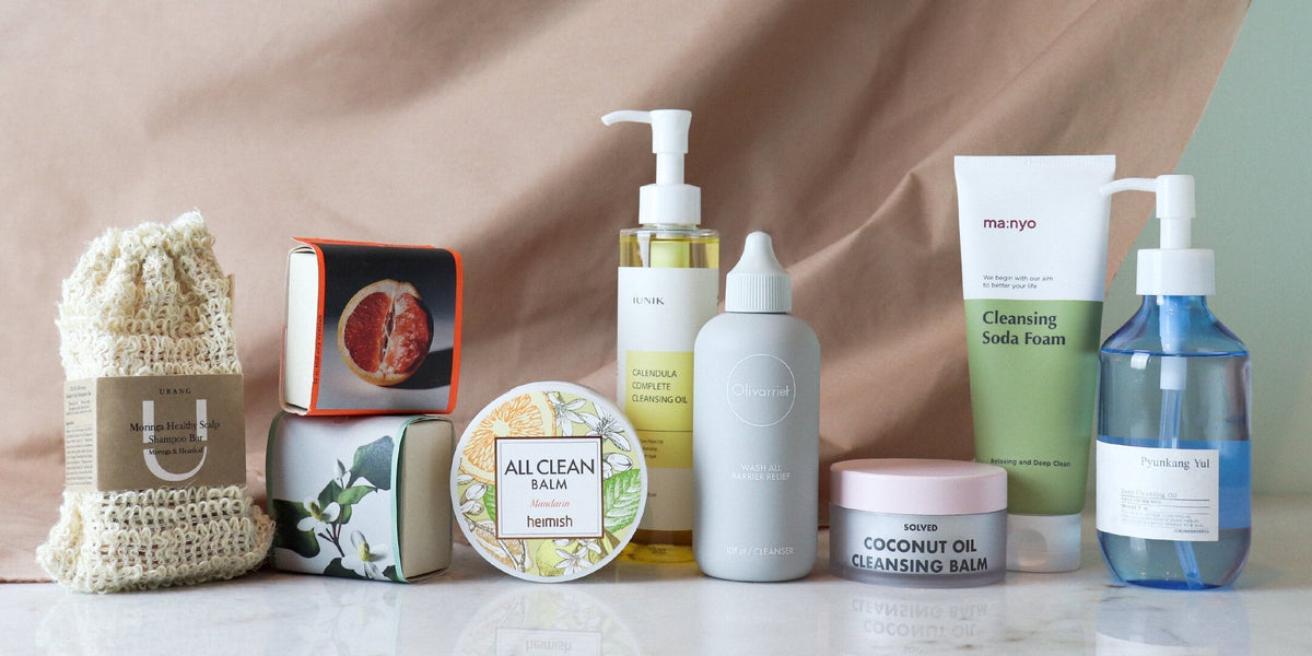 An assortment of various skincare products, including bottles, tubes, and jars, arranged neatly on a white surface against a neutral backdrop.