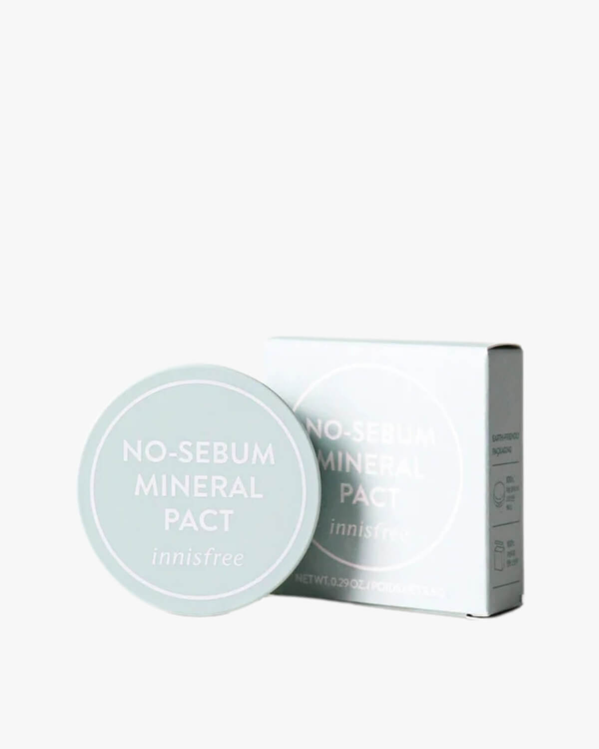 A round mint green powder compact shown next to its square retail box.