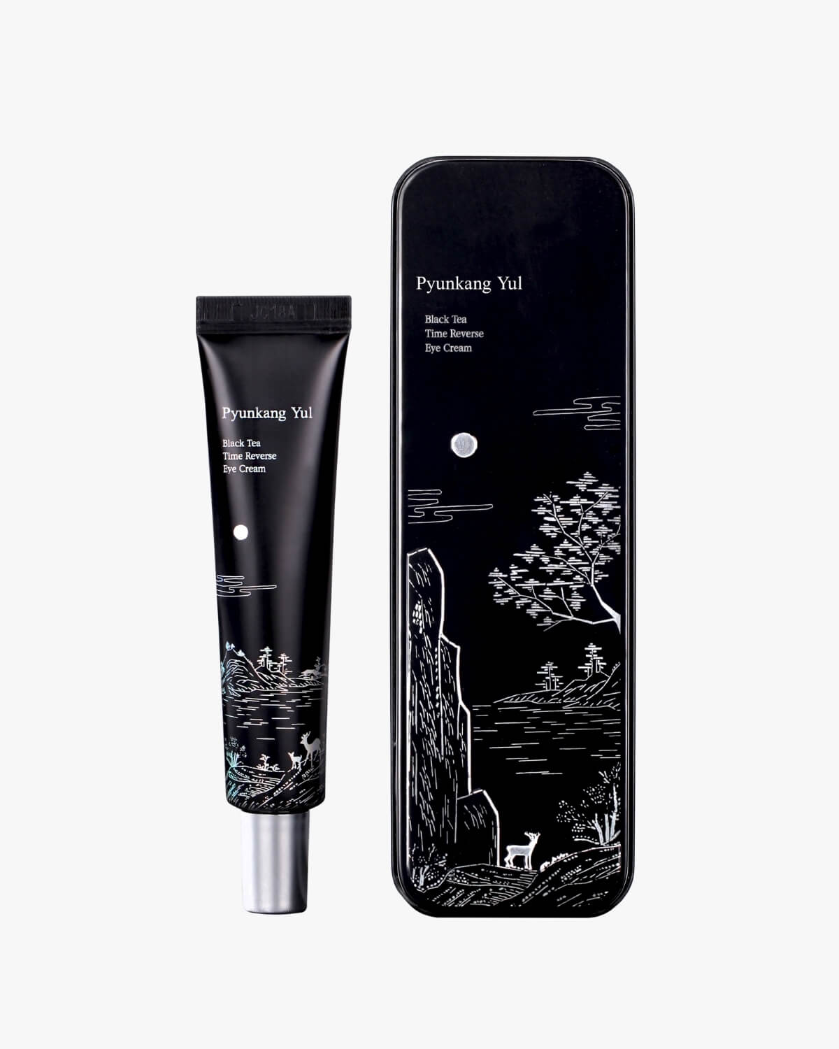 A slender black tube of eye cream standing next to its decorative black metal storage tin.