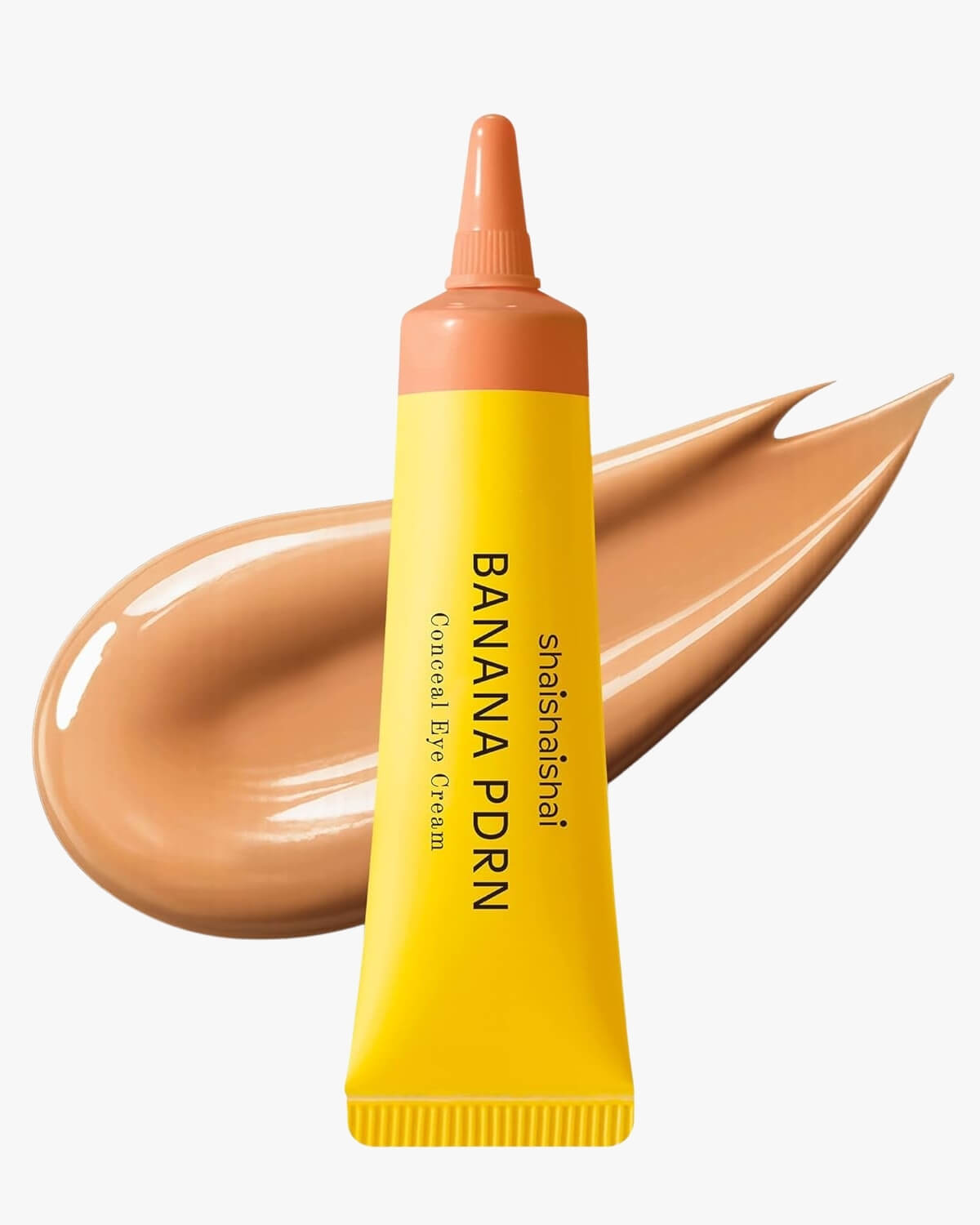 A yellow tube of shaishaishai Banana PDRN Conceal Eye Cream with a warm, medium-brown caramel cream swatch in the background.