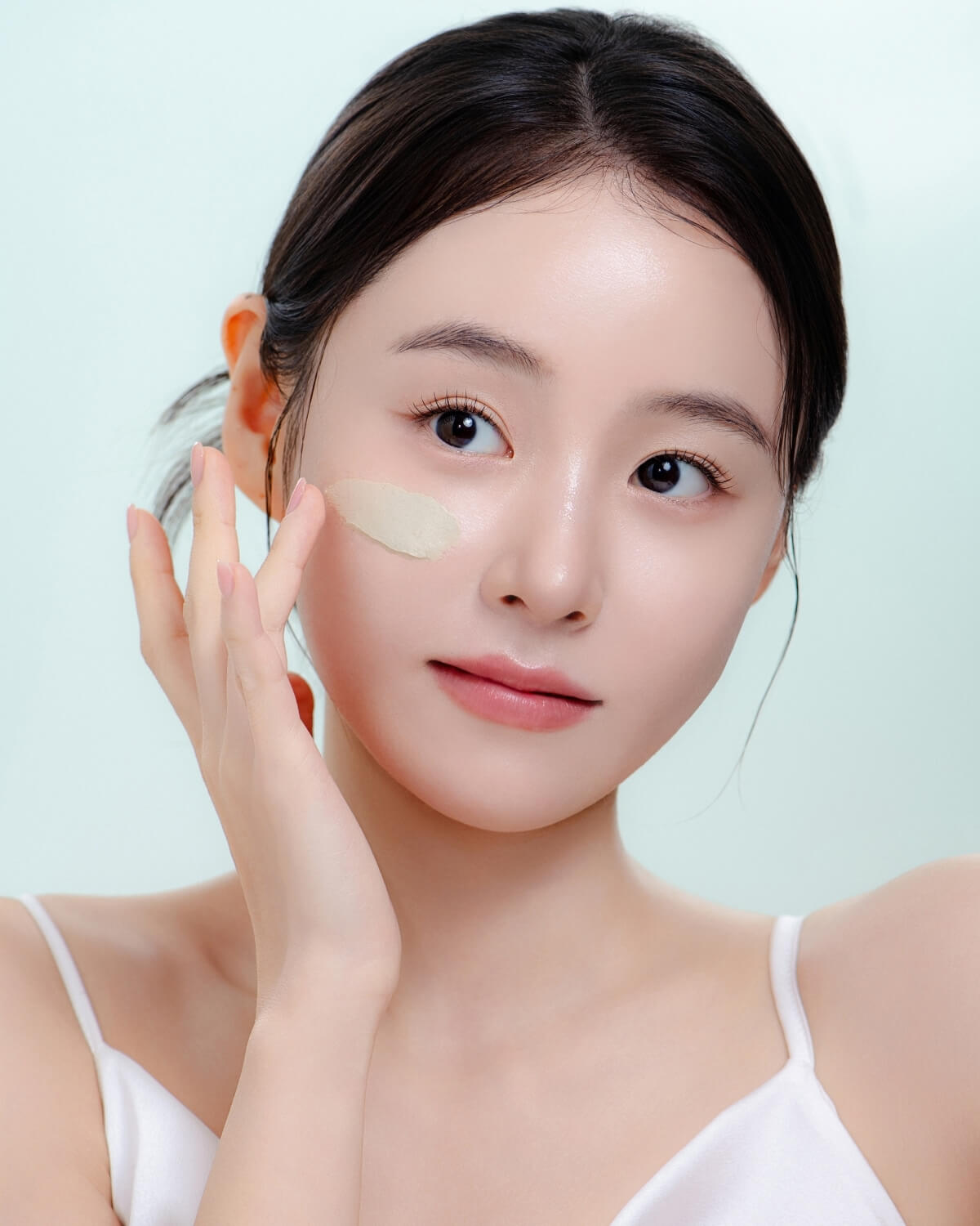 A model applies the Aperire Be Frozen Pore Mask to her cheek for cooling and pore-tightening benefits.
