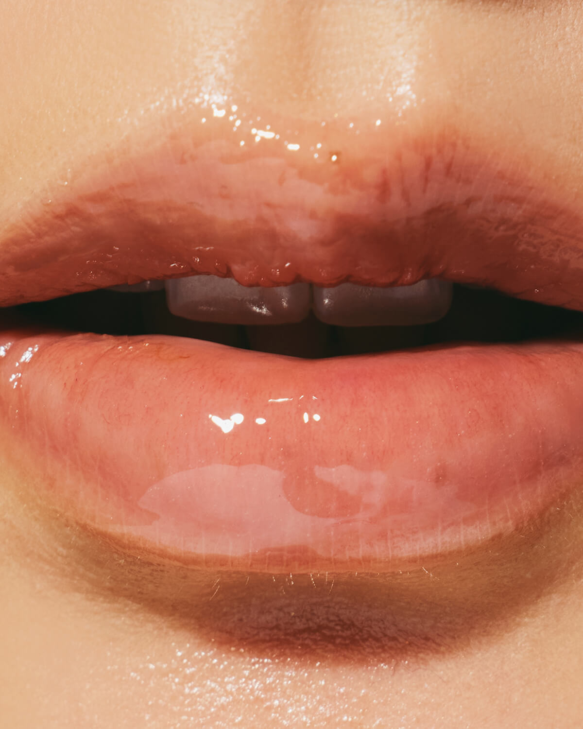Extreme close-up of glossy, hydrated lips showing the finish of Haruharu Wonder Peptide Glowy Balm.