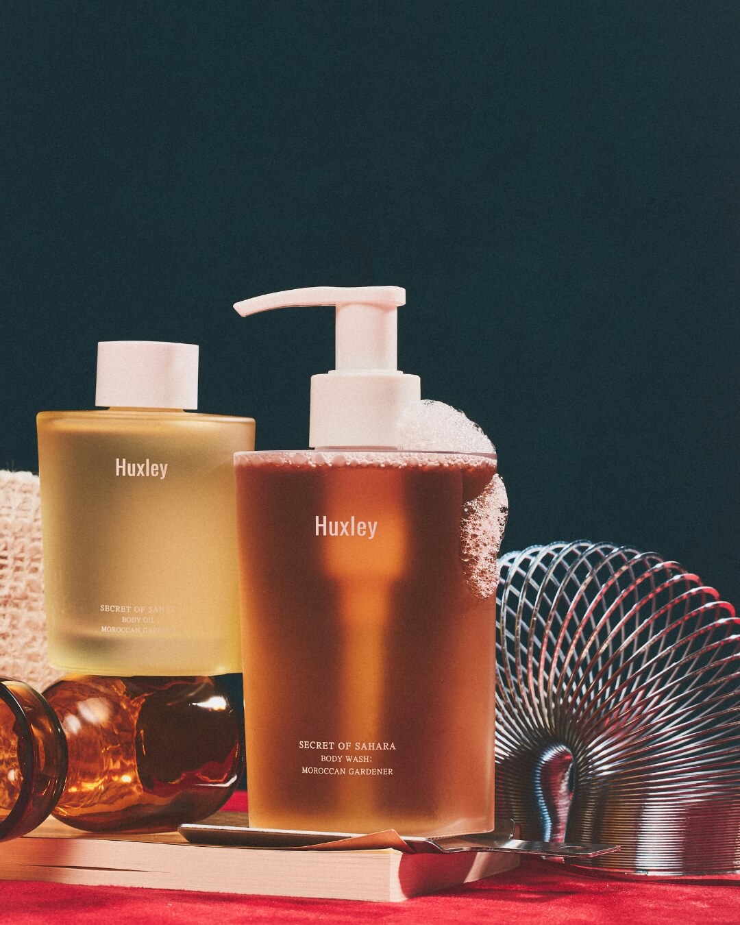 Huxley body wash bottle with foam alongside Moroccan Gardener body oil.