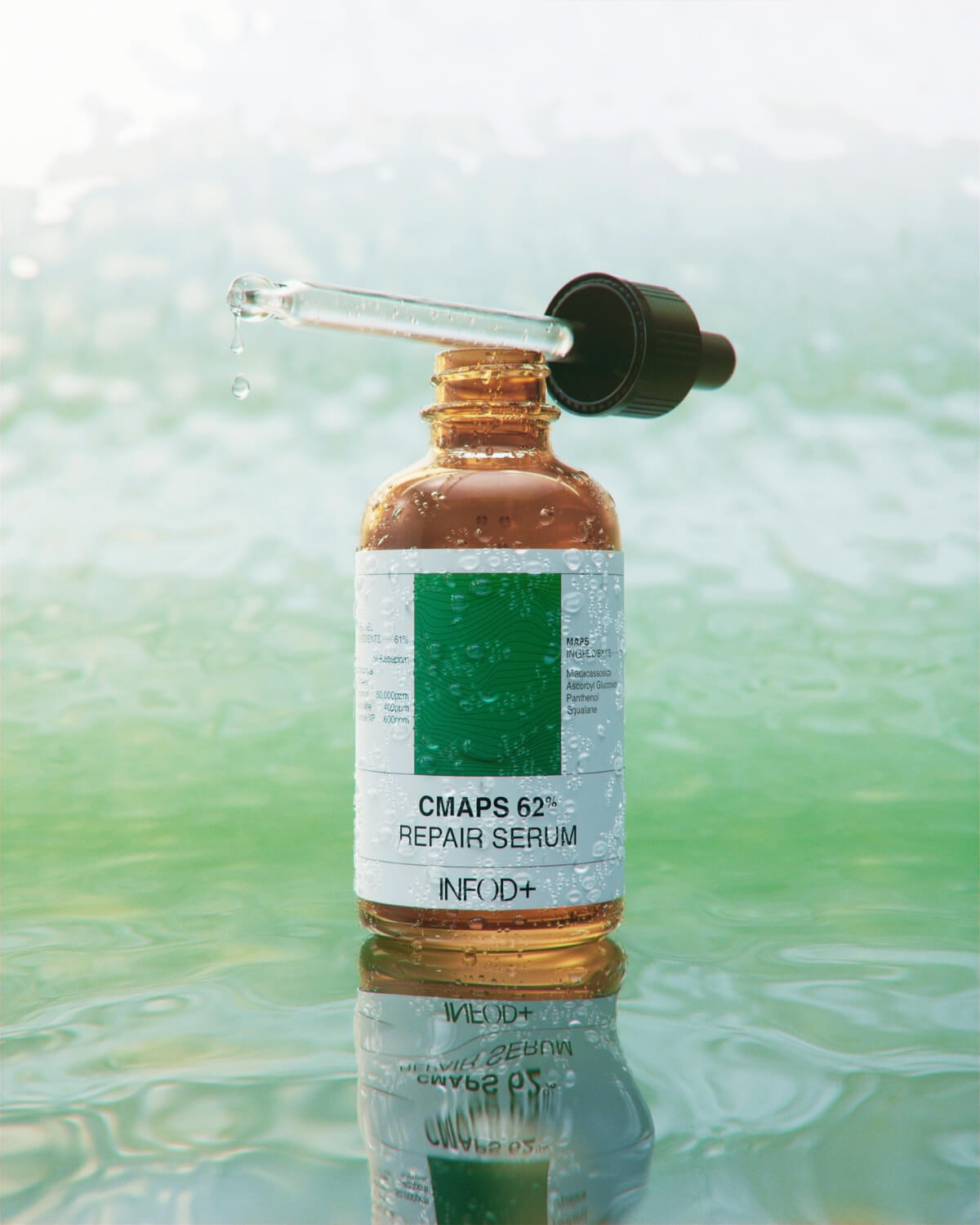 An amber glass dropper bottle with its cap and dropper resting diagonally across its opening. A clear liquid drop is suspended from the dropper's tip. The bottle is reflected in a rippling green body of water.