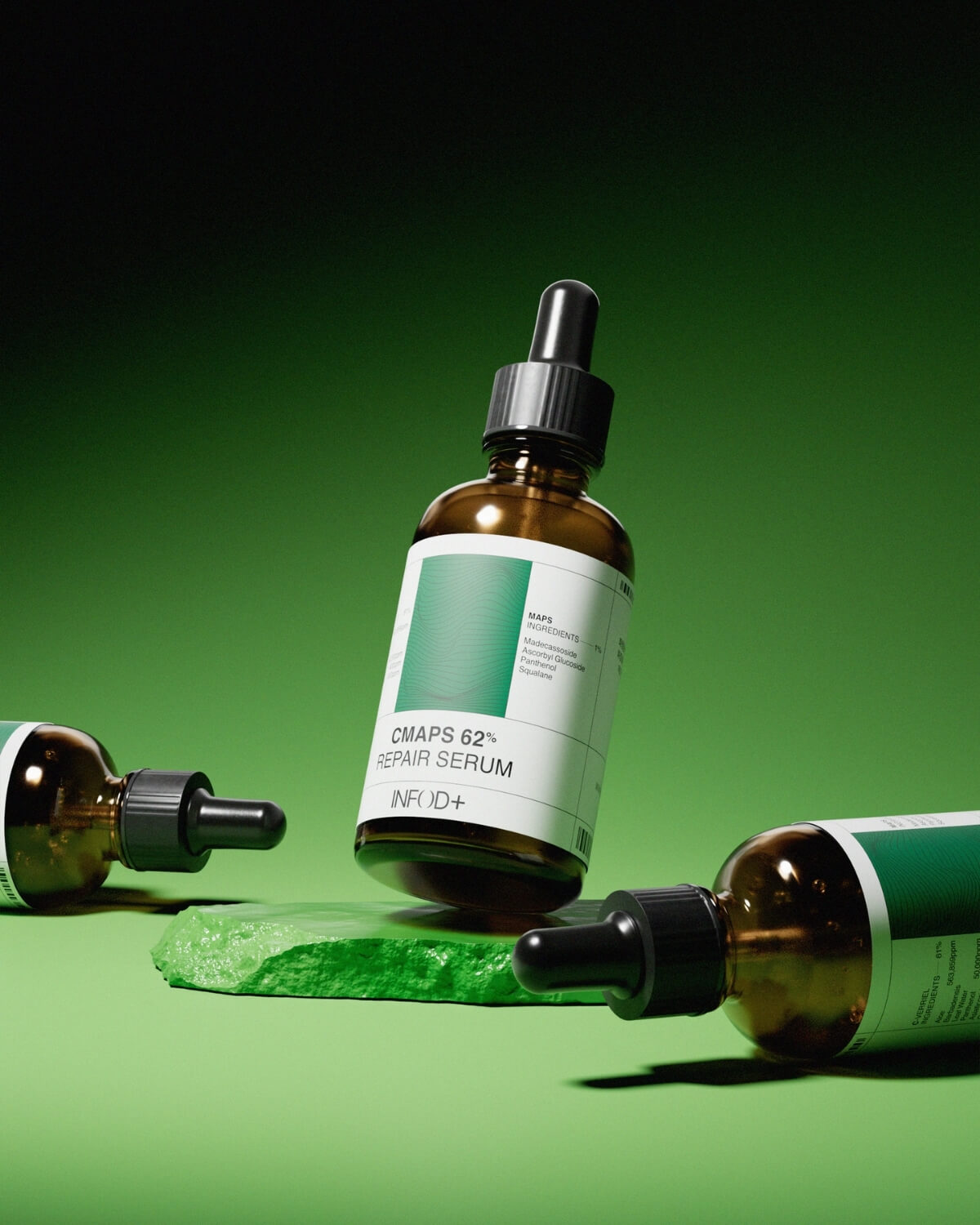 Three amber glass dropper bottles are arranged on a vibrant green surface, which includes a textured, jagged green rock. One bottle stands upright on the rock, while two others lie on their sides around it. The background is a deep green.