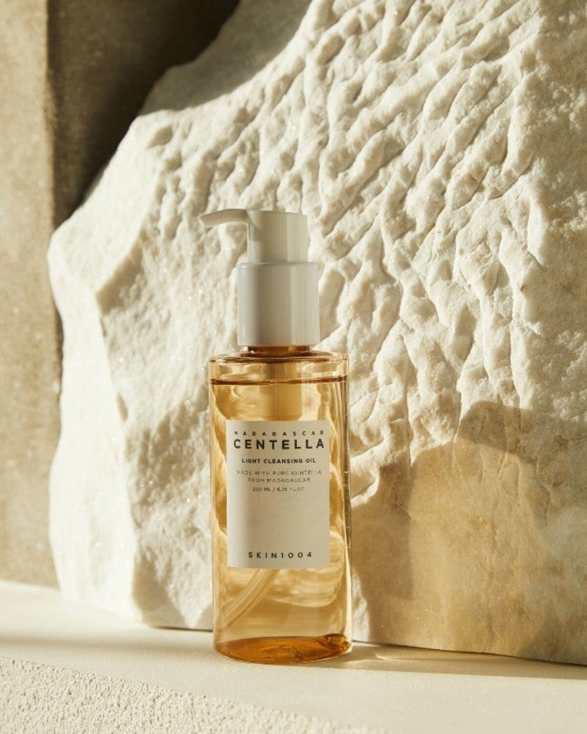 Skin1004 Madagascar Centella Light Cleansing Oil, product image on a white background with rocky texture