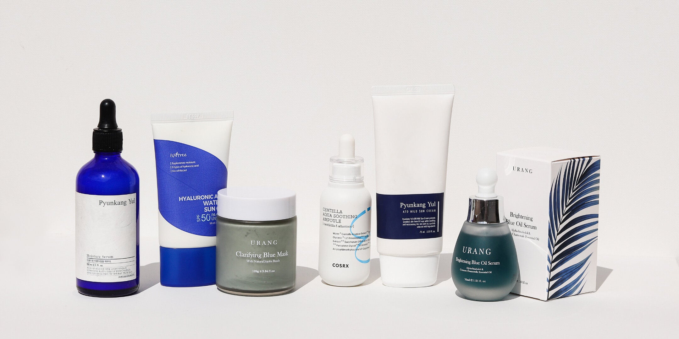 a group of skincare products in a row against white background