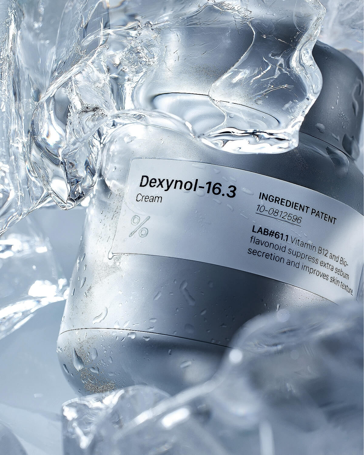 Close-up of the Dexynol-16.3 Cream jar surrounded by melting ice/ice shards, emphasizing its moisturizing and cooling properties.