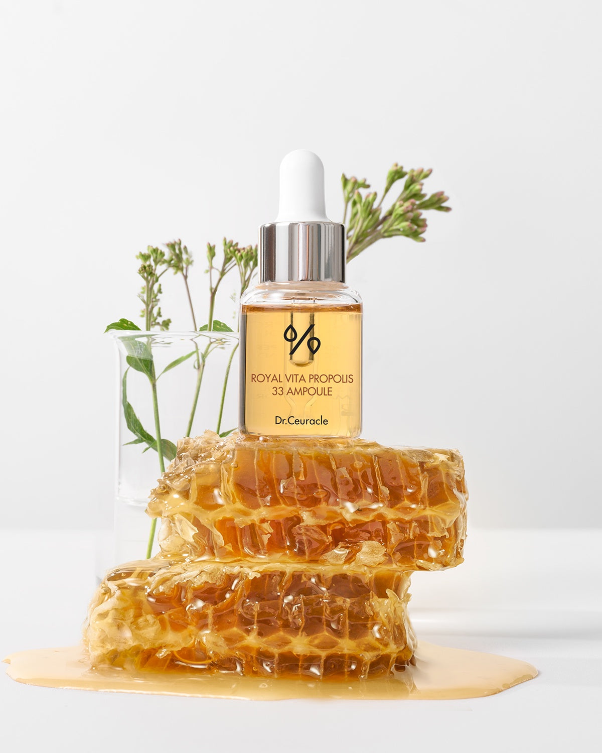 Dr. Ceuracle Royal Vita Propolis 33 Ampoule bottle on a stack of honeycomb; hydrating face serum for irritated, dull skin.