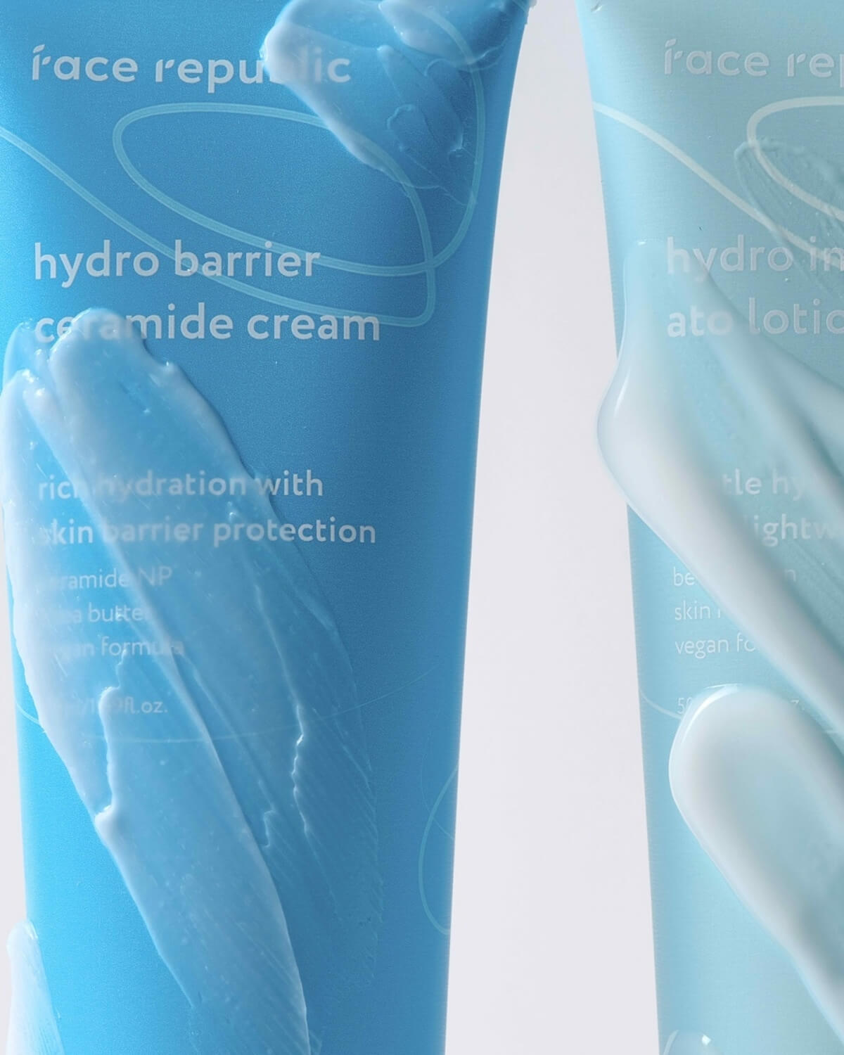 Close-up of blue tubes with white cream texture smears showing product consistency.