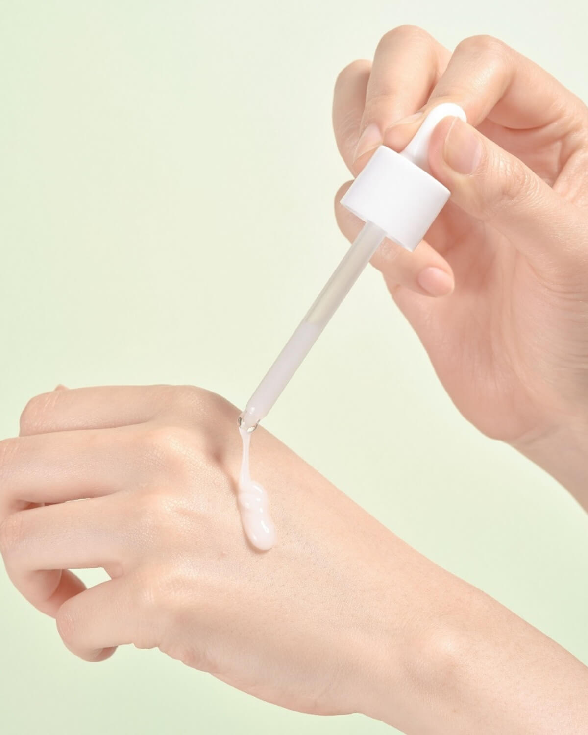 Applying Face Republic tea tree serum with a dropper on the back of a hand.