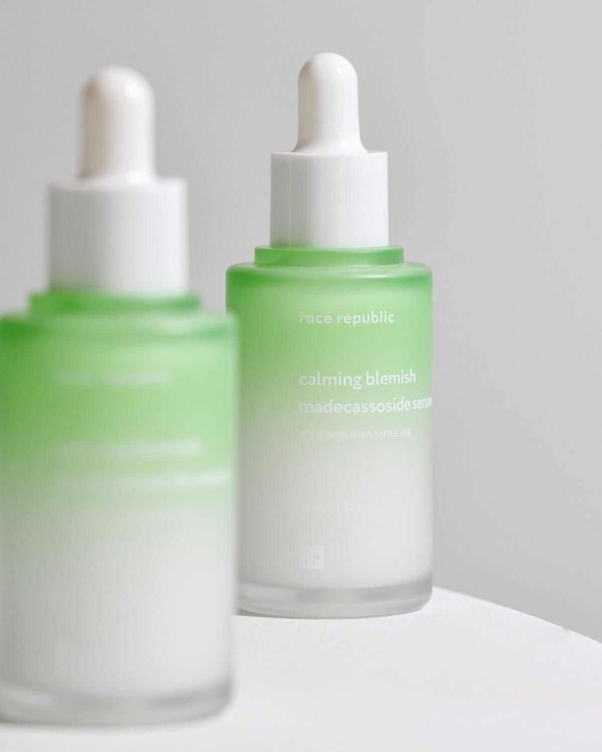 Two frosted glass bottles of Face Republic Calming Blemish Madecassoside Serum.