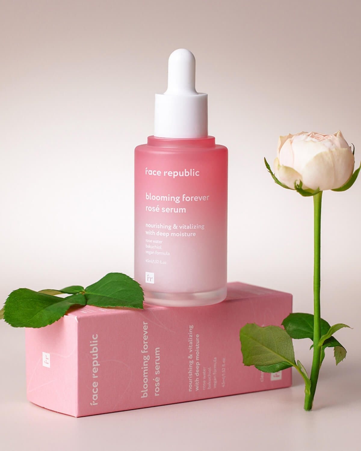 Face Republic Rosé Serum bottle and packaging next to a fresh pink rose.