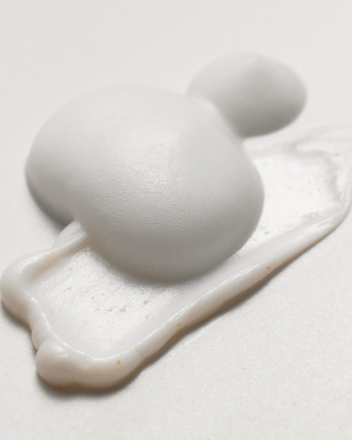 Close-up texture shot of the thick, white creamy foam of the Face Republic Gold Mineral Cleanser.