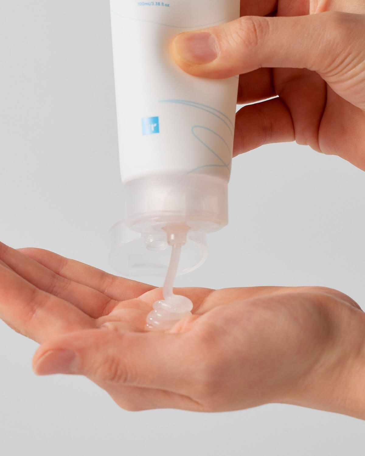 A person squeezing a clear gel-like Face Republic Hydro Derma Gentle Cleanser onto their palm.