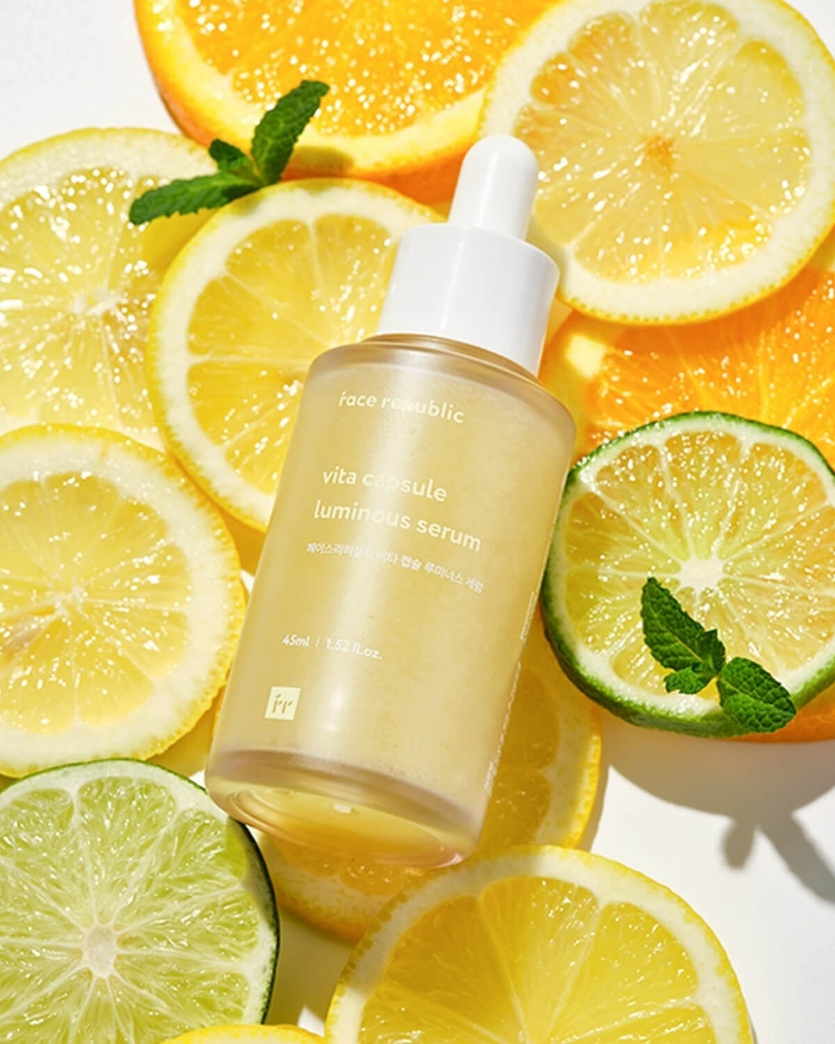 Vitamin-C serum bottle styled with vibrant citrus slices of lemon, lime, and orange.