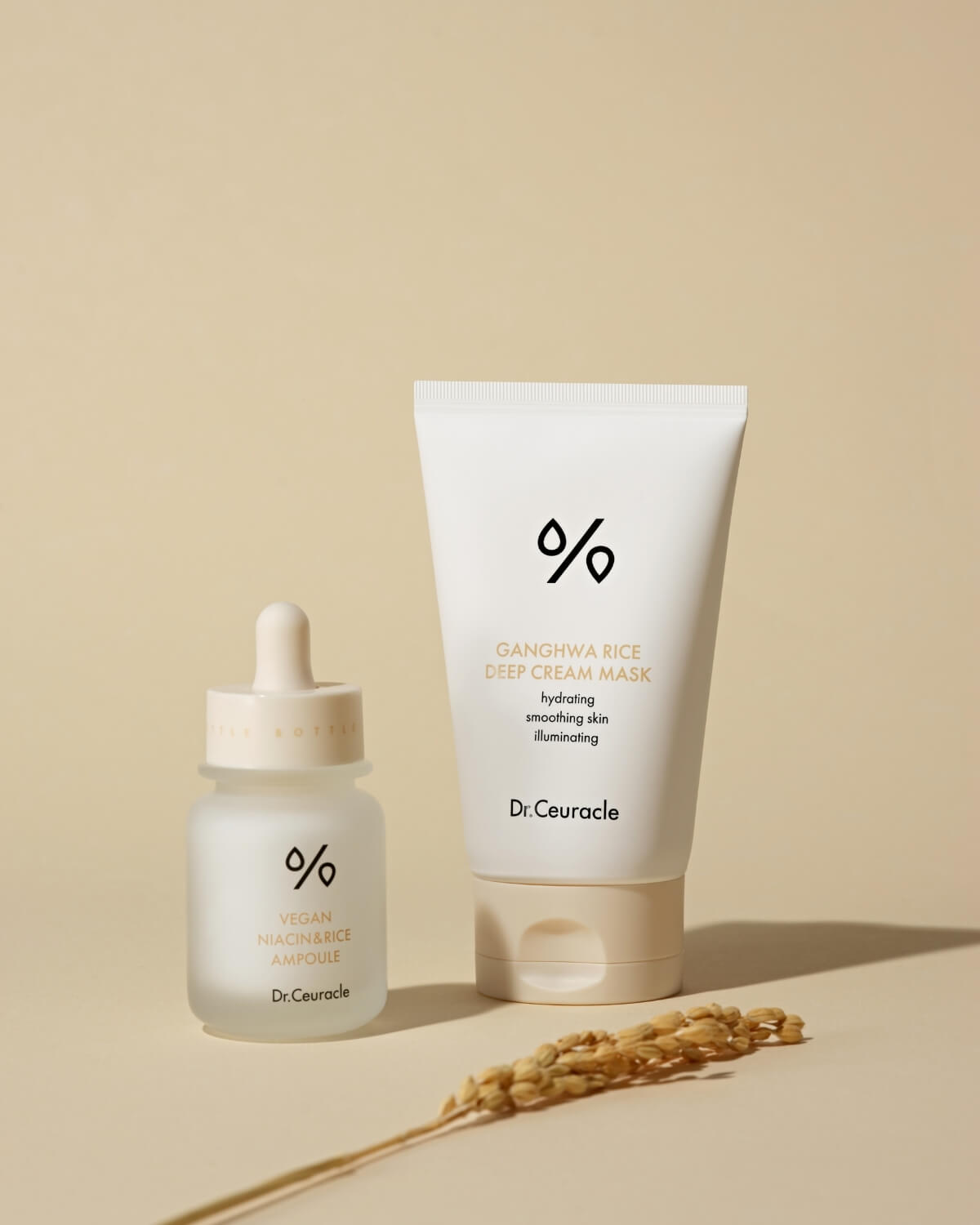 Dr. Ceuracle Ganghwa Rice Deep Cream Mask and Vegan Niacin & Rice Ampoule on a beige background with rice stalks.