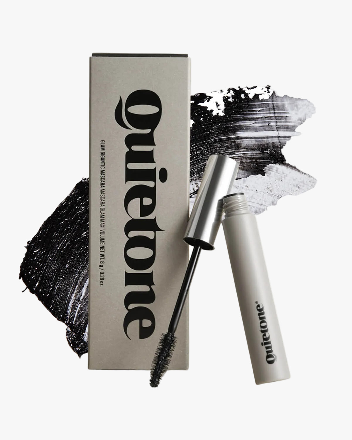 Quietone Glam Gigantic Mascara tube and wand displayed with product packaging and black mascara swatches.