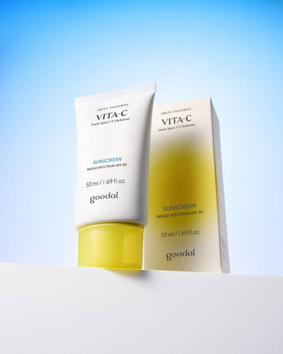 Goodal Vita-C Dark Spot UV Defense Sunscreen tube standing next to its product packaging box on a minimalist white surface.