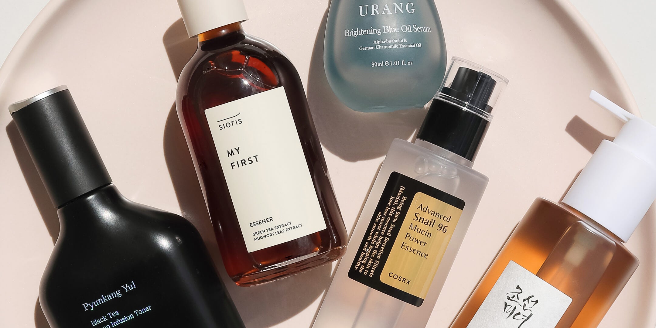 Group of products lay flat on pink prop