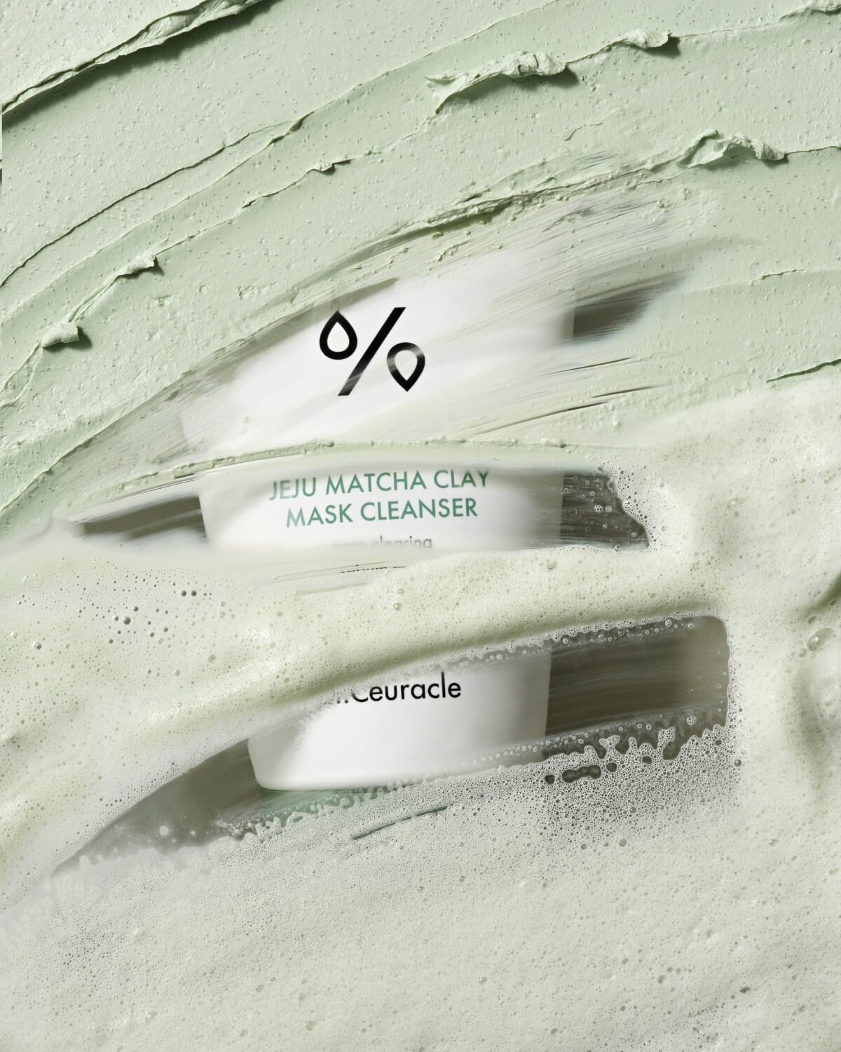 Close-up of green clay mask texture and foam over Dr. Ceuracle Jeju Matcha Cleanser tube.