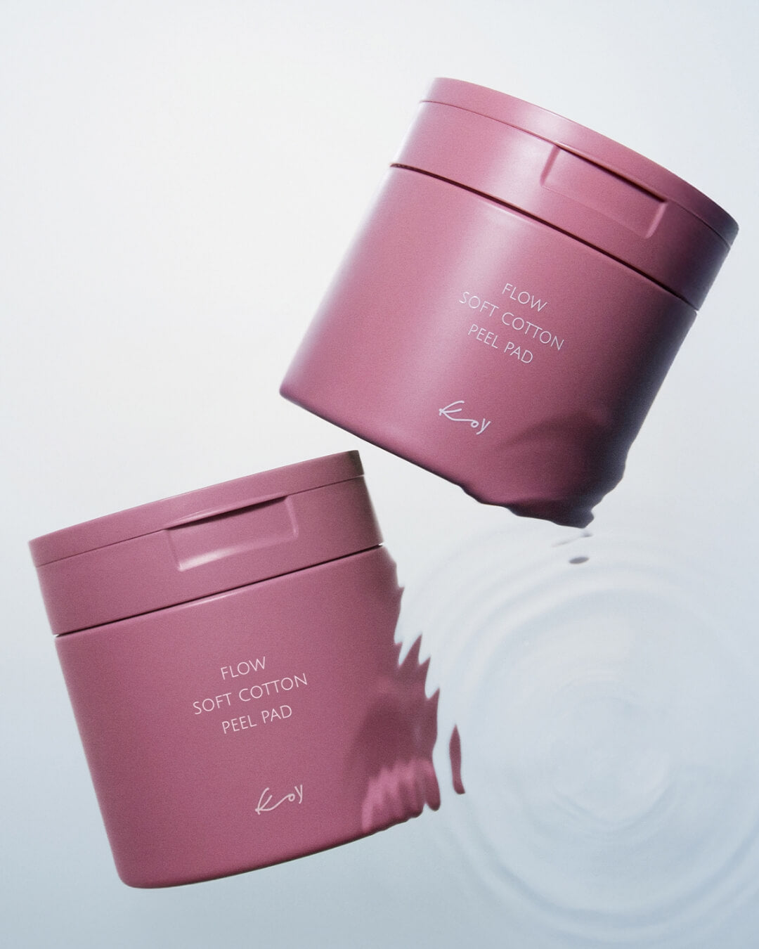 Two pink jars of Koy Flow Soft Cotton Peel Pad floating over clean, rippling water.