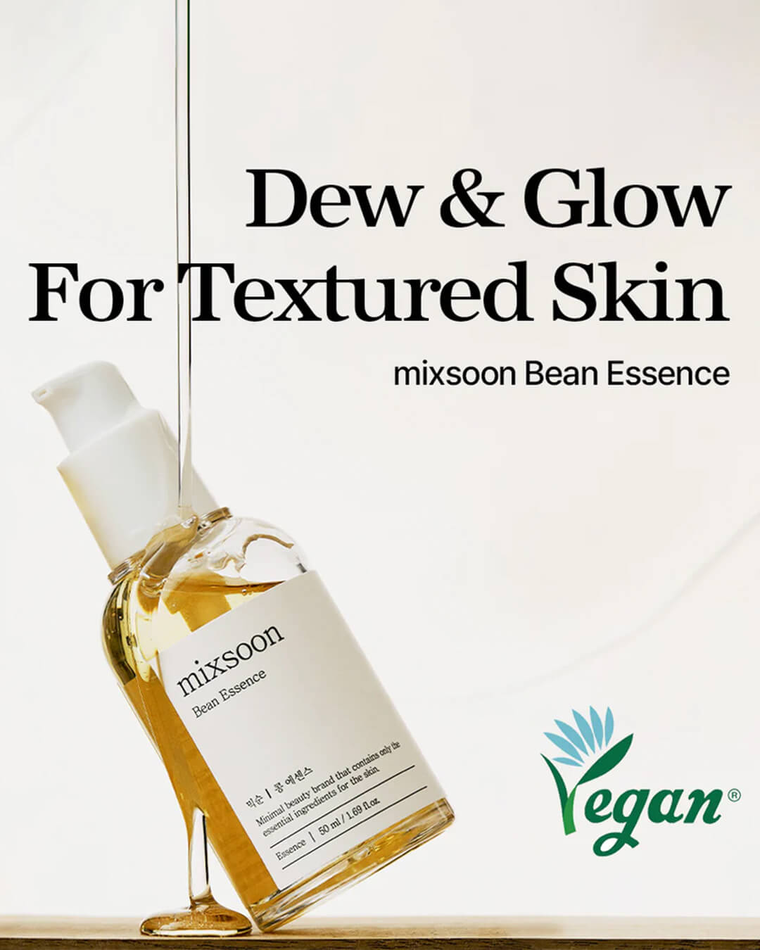 A stylized marketing graphic for the Mixsoon Bean Essence, showing the bottle tilted with the essence dripping down. Large text reads 'Dew & Glow For Textured Skin,' and the Vegan certification logo is visible, emphasizing its benefits for texture and ethical sourcing.