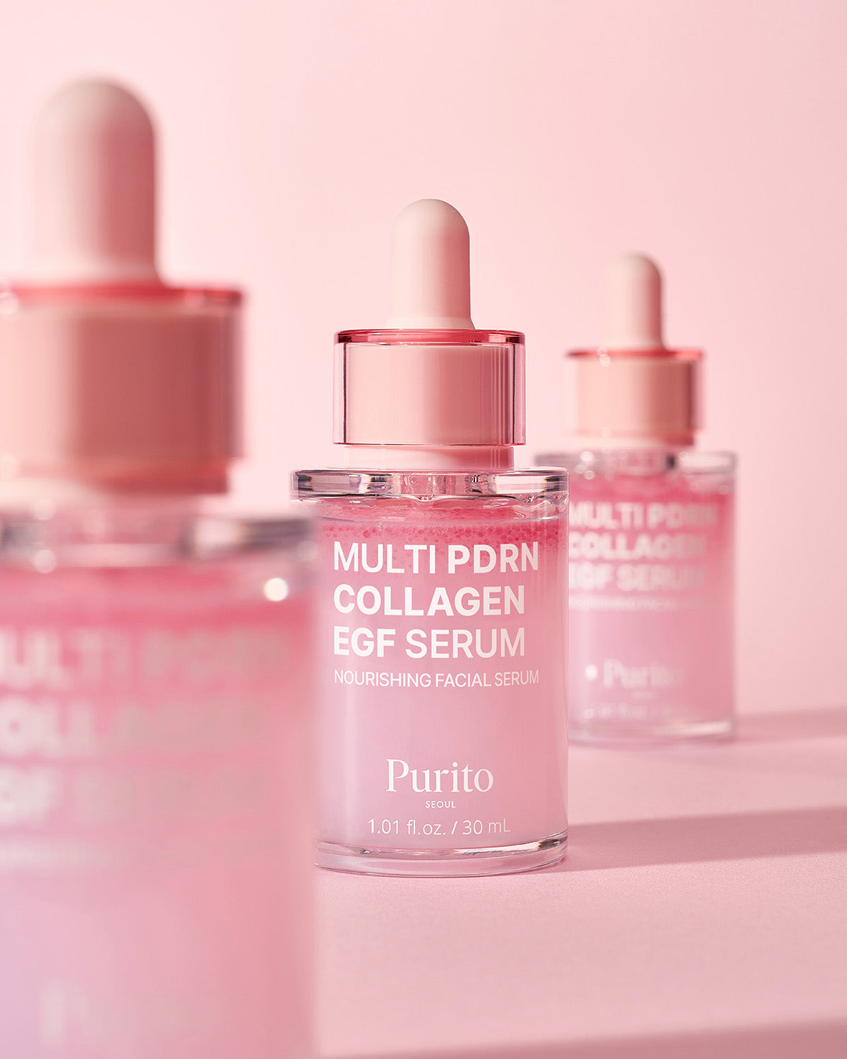 Three bottles of Purito Multi PDRN Collagen EGF Serum arranged on a soft pink background.