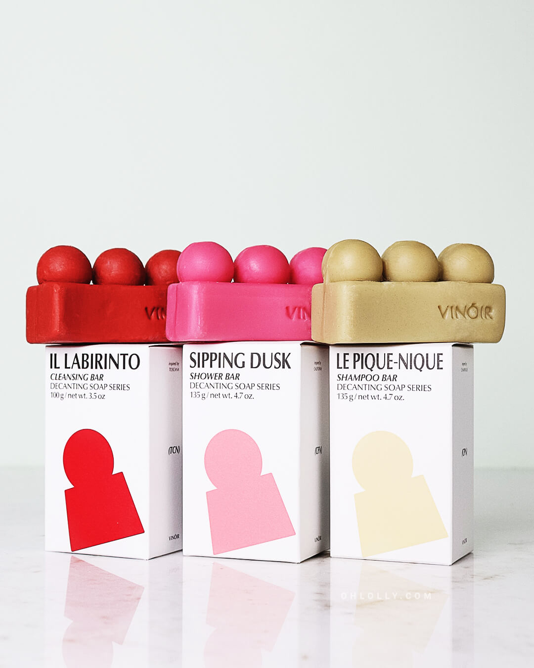 Ohlolly Korean Skincare Vinoir Decanting Soap Series Gift Set including Le Pique-Nique Shampoo Bar, Il Labirinto Cleansing Bar, Sipping Duck Shower Bar. Bar soaps on top of boxes.