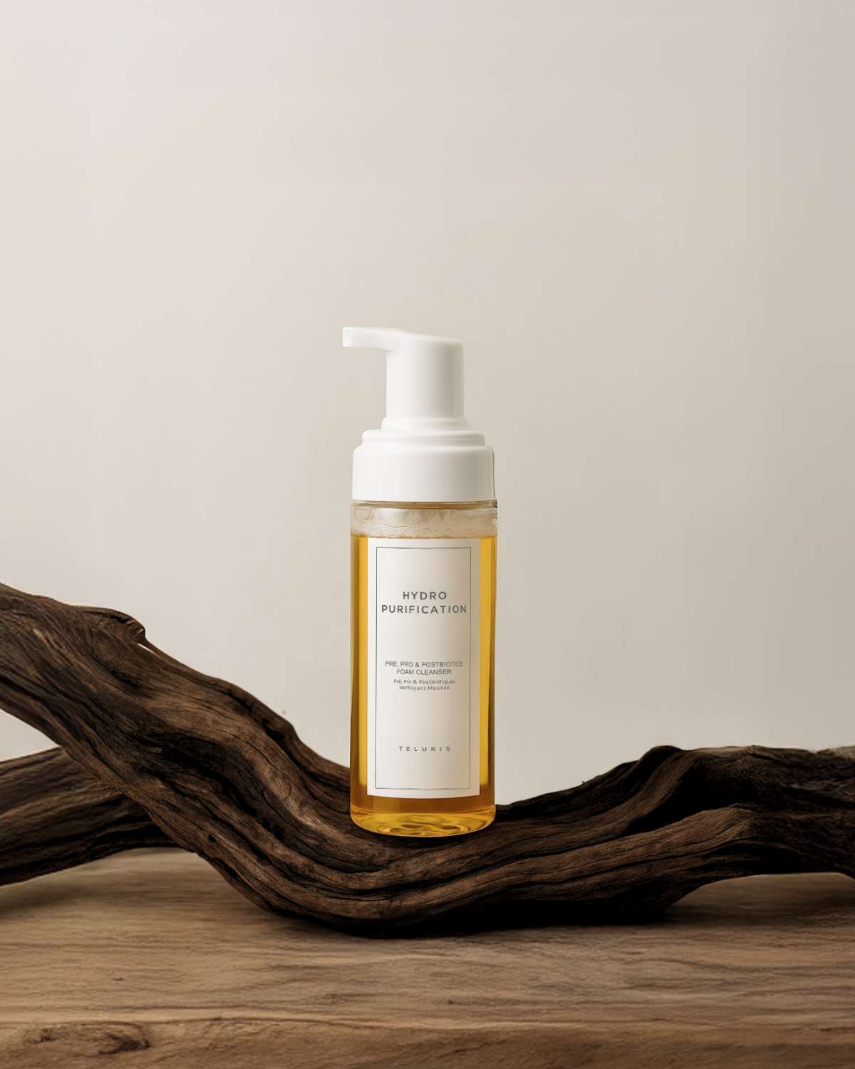 Teluris Hydro Purification bottle displayed on a natural wood branch for an organic skincare aesthetic.