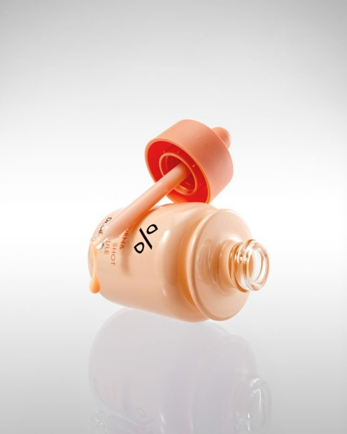 Close-up of PDRN & Retinol Shot Ampoule bottle tilted with a glass dropper showing product texture.