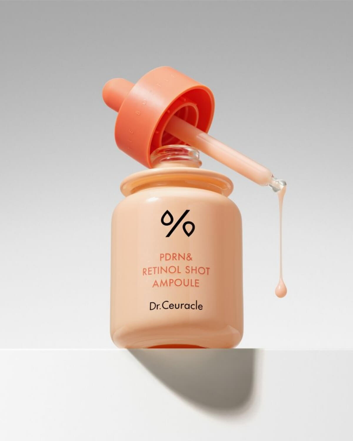 Dr. Ceuracle PDRN & Retinol Shot Ampoule with product dripping from the glass dropper.