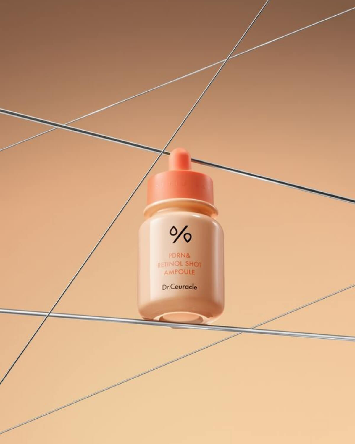 Dr. Ceuracle PDRN & Retinol Shot Ampoule bottle displayed in a modern, geometric setting with wires.
