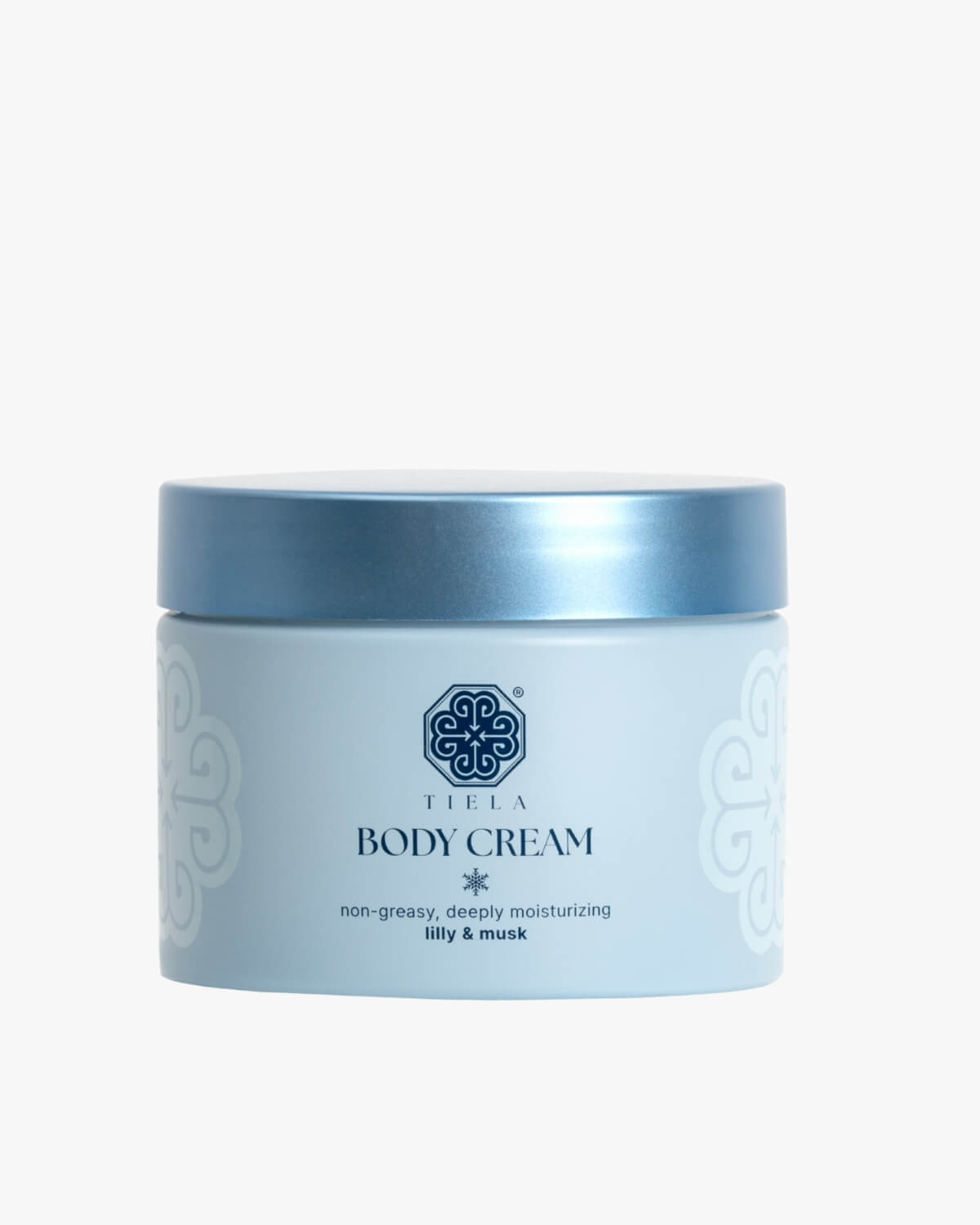Front view of a round Tiela Body Cream jar in light blue with a metallic blue lid, labeled "non-greasy, deeply moisturizing lilly & musk."