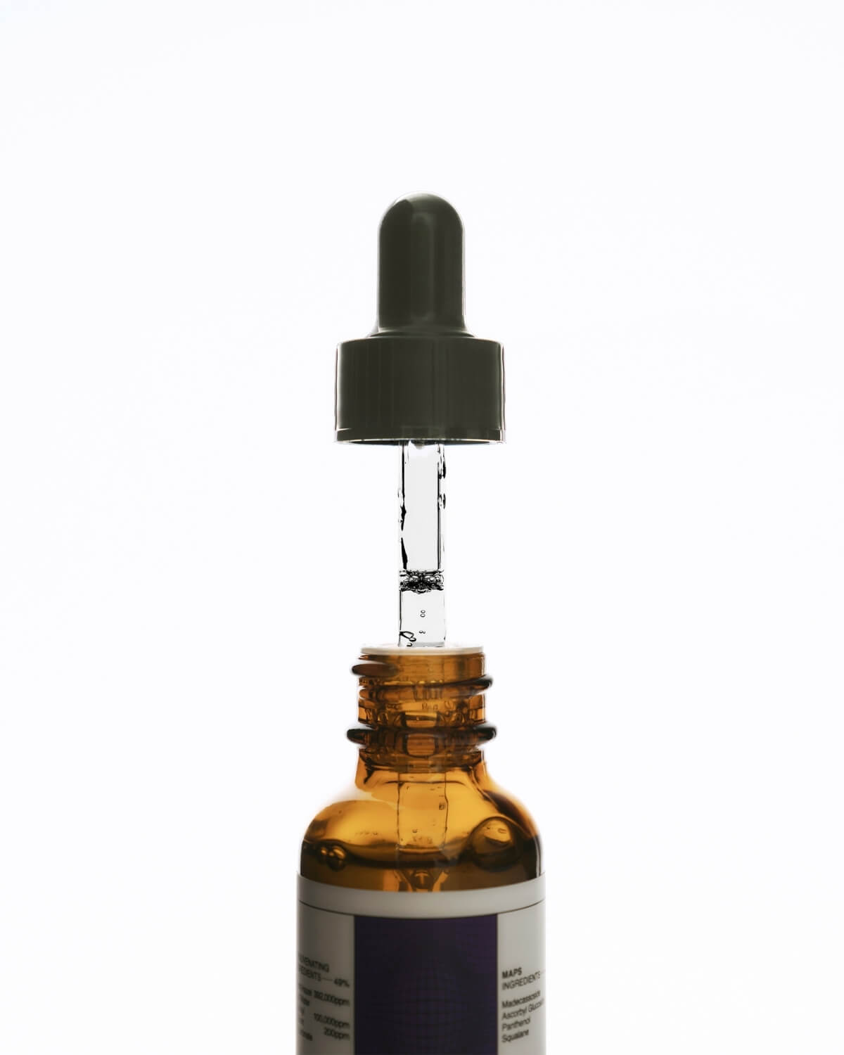 Close-up shot of the dropper pipette being placed back into the amber glass bottle of the RE²MAPS 50% Firming Serum.