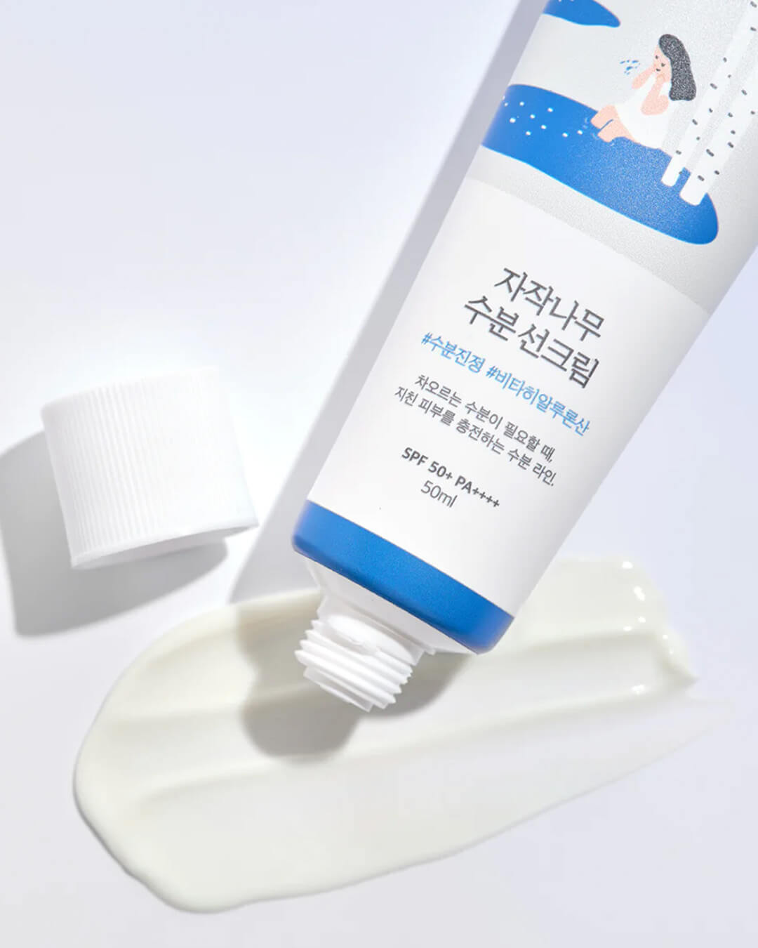 The Round Lab Birch Moisturizing Sunscreen is squeezed out of its tube, showcasing the smooth, creamy, and non-greasy texture of the white sun cream.