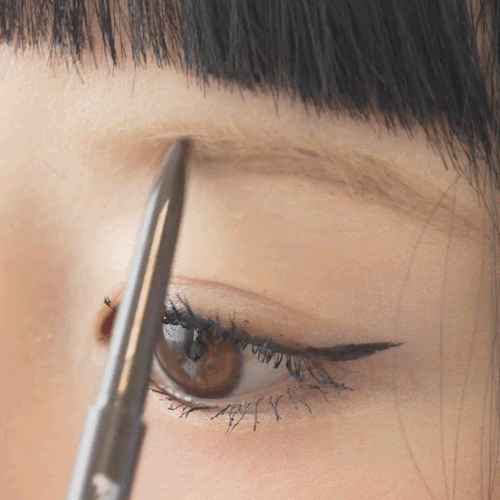 An animated demonstration of the Peripera Speedy Skinny Brow pencil, showing a hand using the ultra-slim 1.5mm tip to draw precise, hair-like strokes to fill in the model's eyebrow and define its arch.