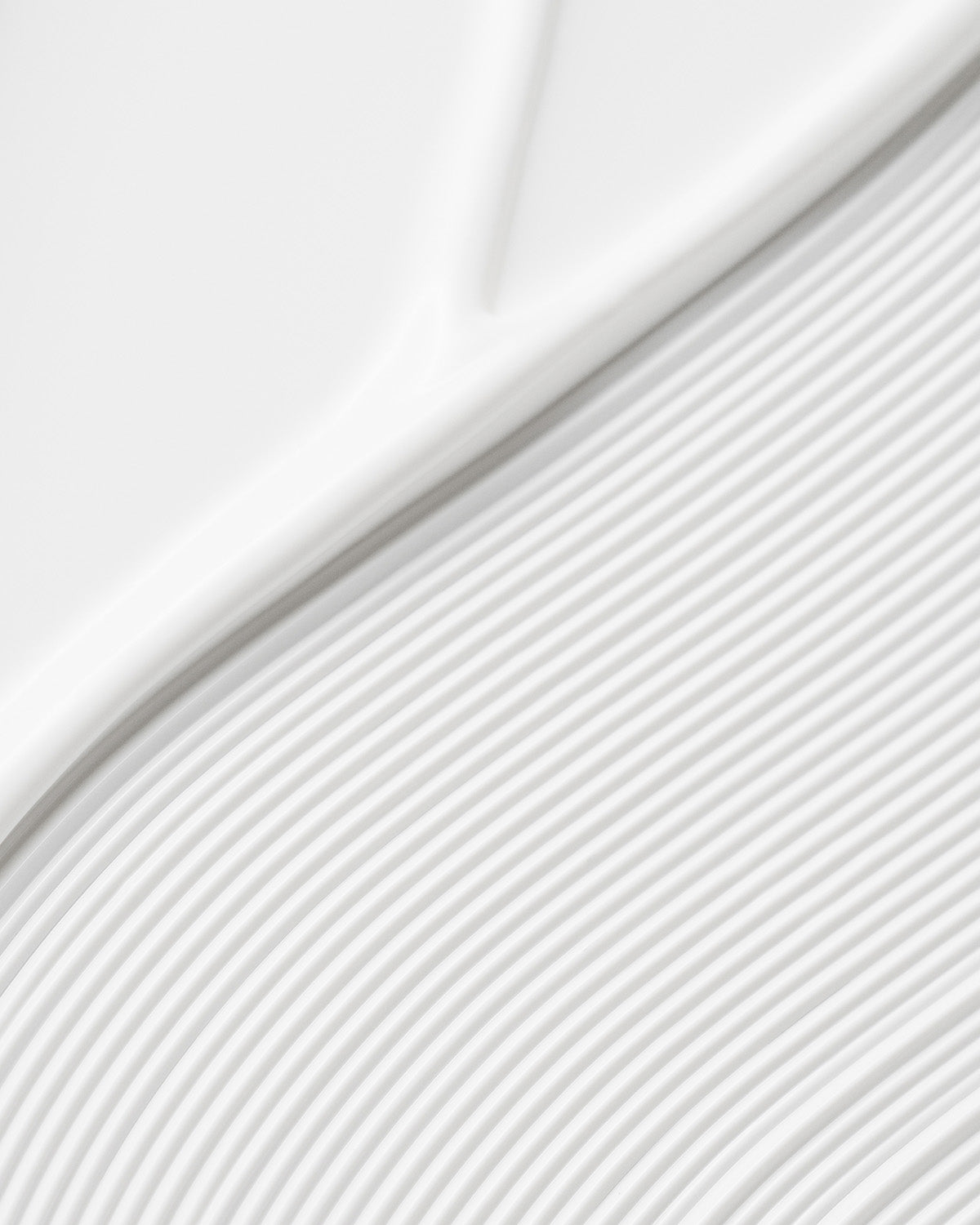 Close-up of smooth, white creamy texture of Purito Sun Day Adventure Sunscreen with wave patterns.