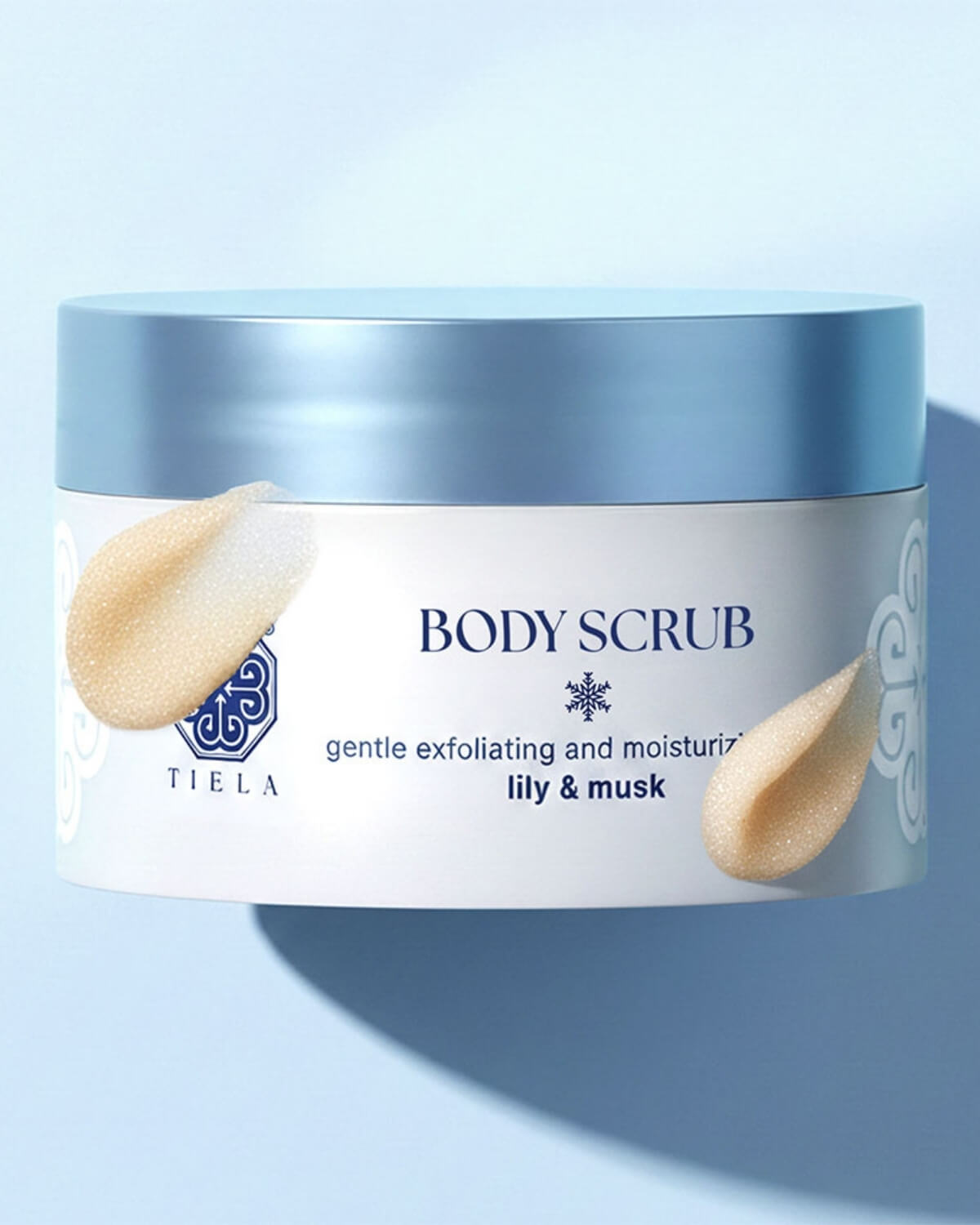 Close-up of a Tiela Lily & Musk body scrub jar featuring two textured product smears on the label.