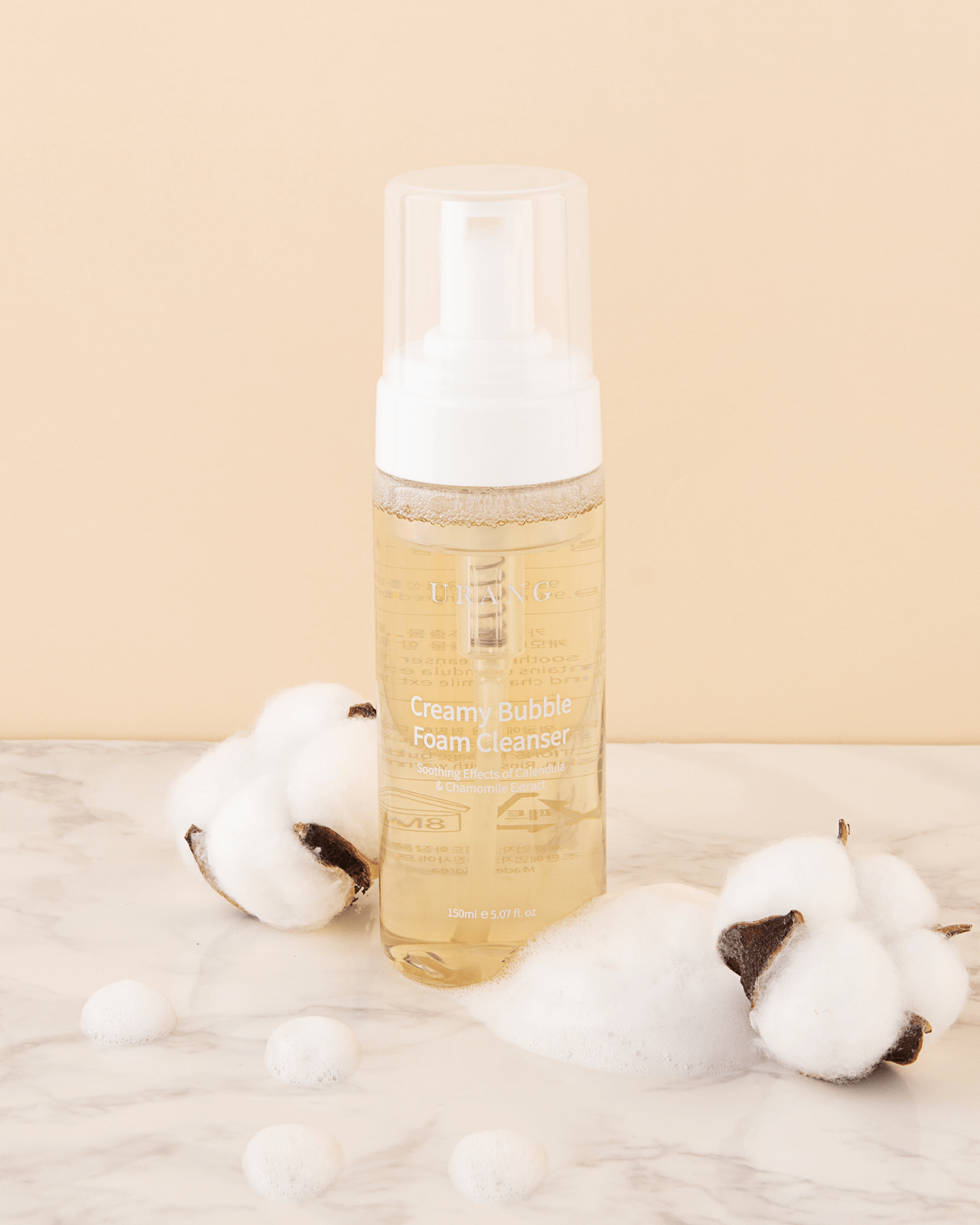 Urang Creamy Bubble Foam Cleanser bottle surrounded by soft cotton, emphasizing the cleanser's gentle, calming, and irritation-free foam.