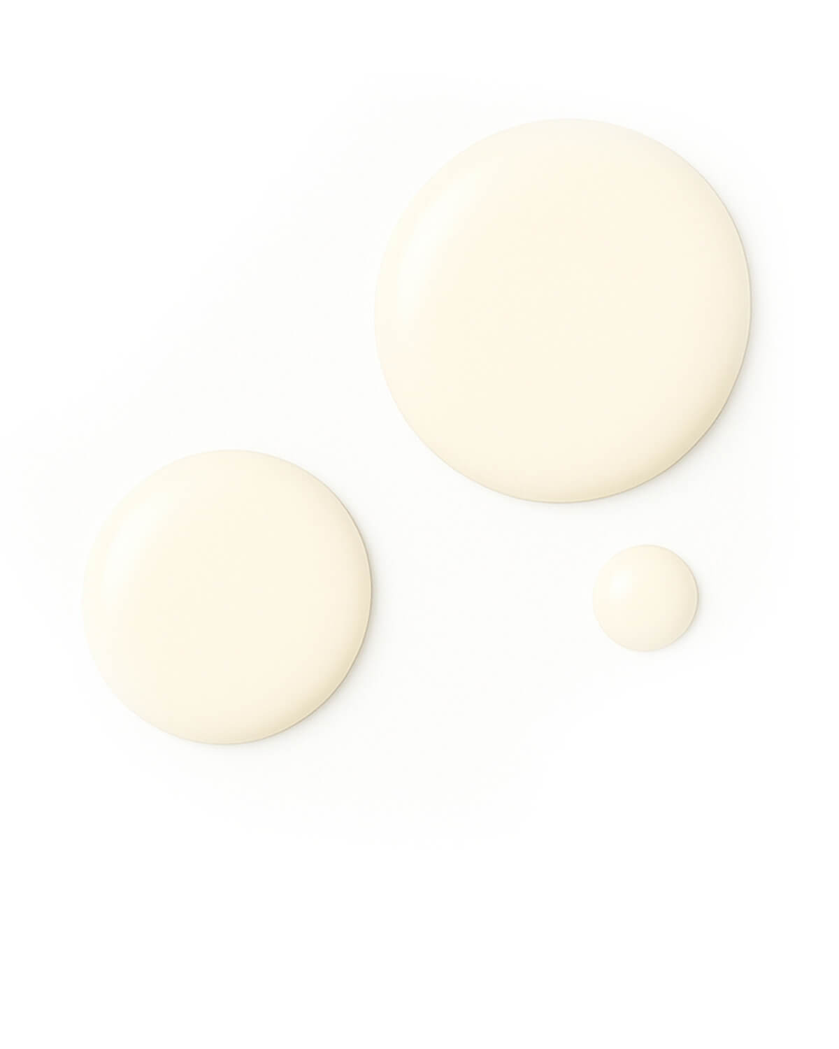 Three circular drops of pale yellow, viscous liquid serum in varying sizes are shown on a pure white background.