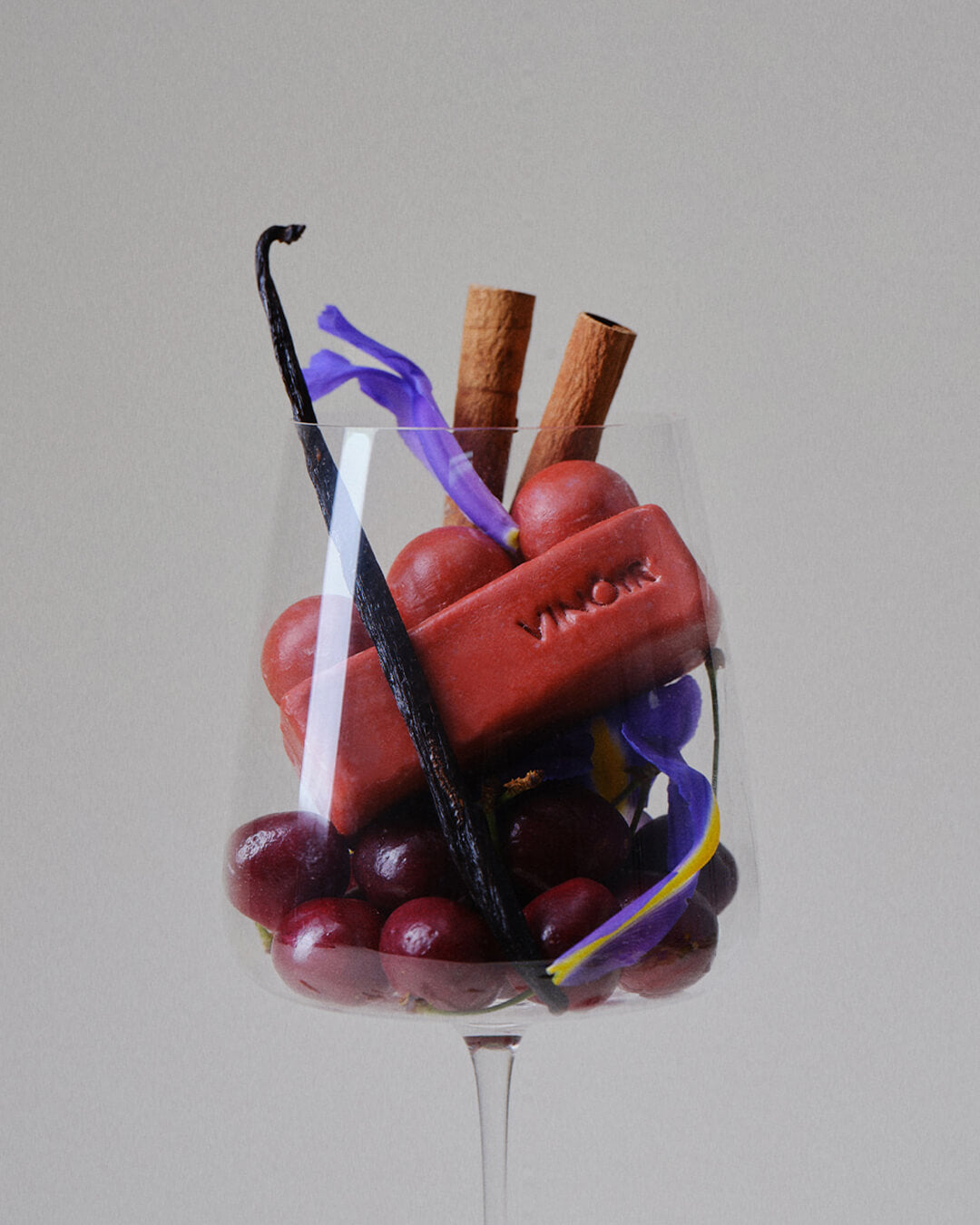 Vinoir Il Labirinto cleansing bar for face and body with black cherry and vanilla scent inspired by Tuscany, ingredients and soap in a wine glass