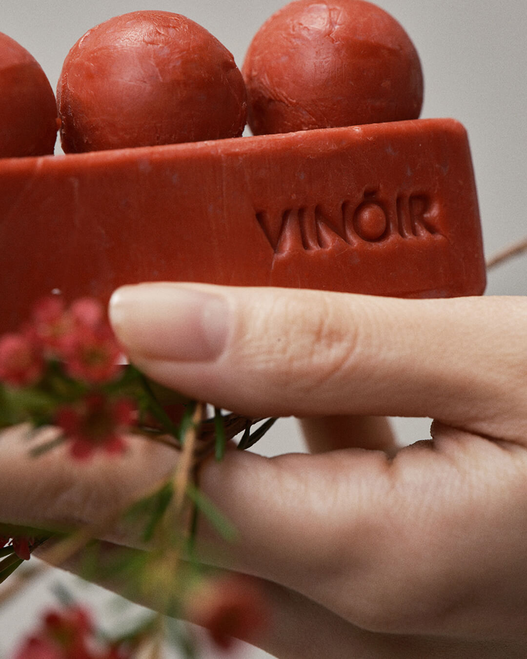 Vinoir Il Labirinto cleansing bar detail showing rich brick red color and flowers, closeup