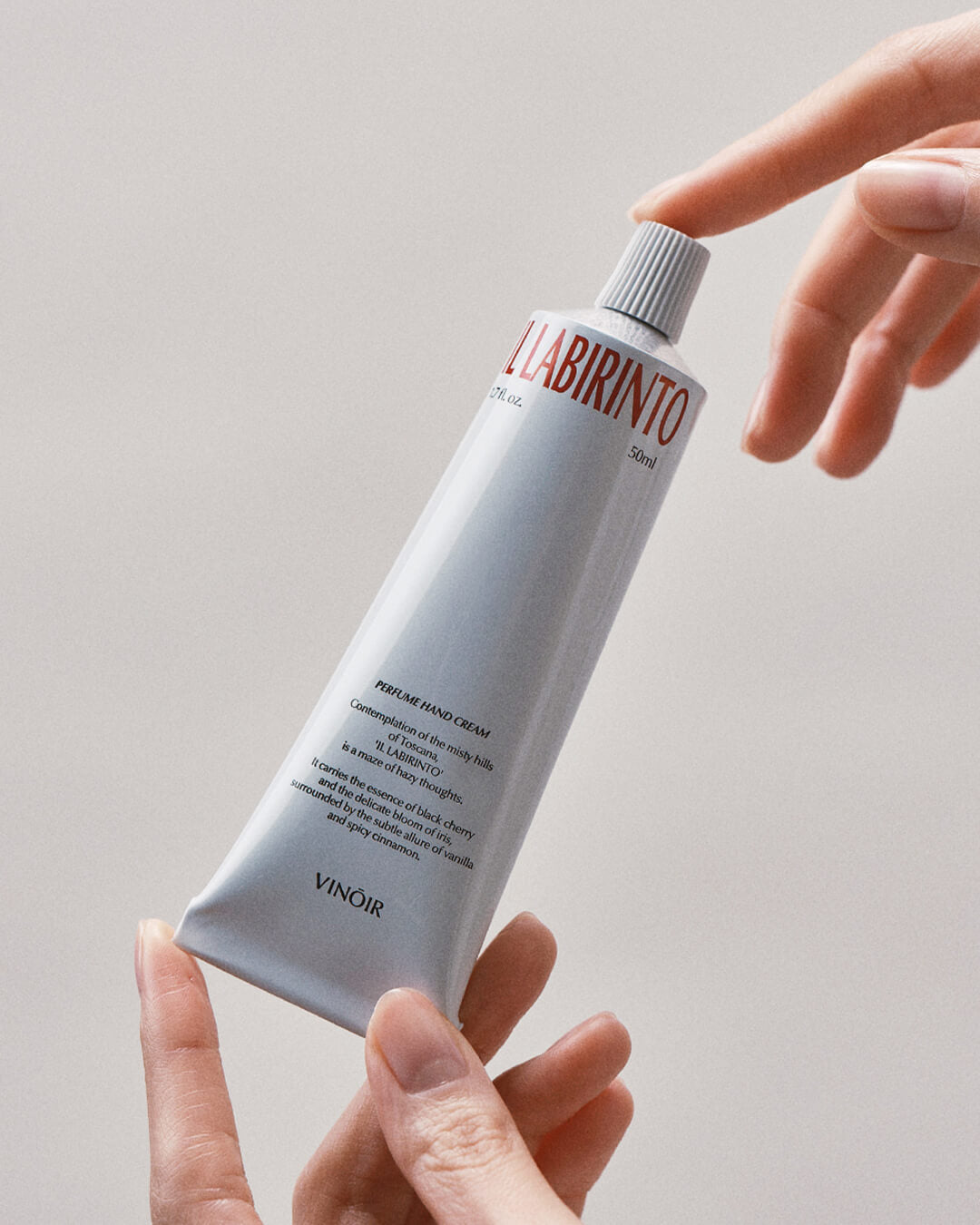 Ohlolly Korean Skincare Vinoir Decanting Hand Cream | Il Labirinto. Scented moisturizer for dry hands. Hands holding Tube. Closeup.