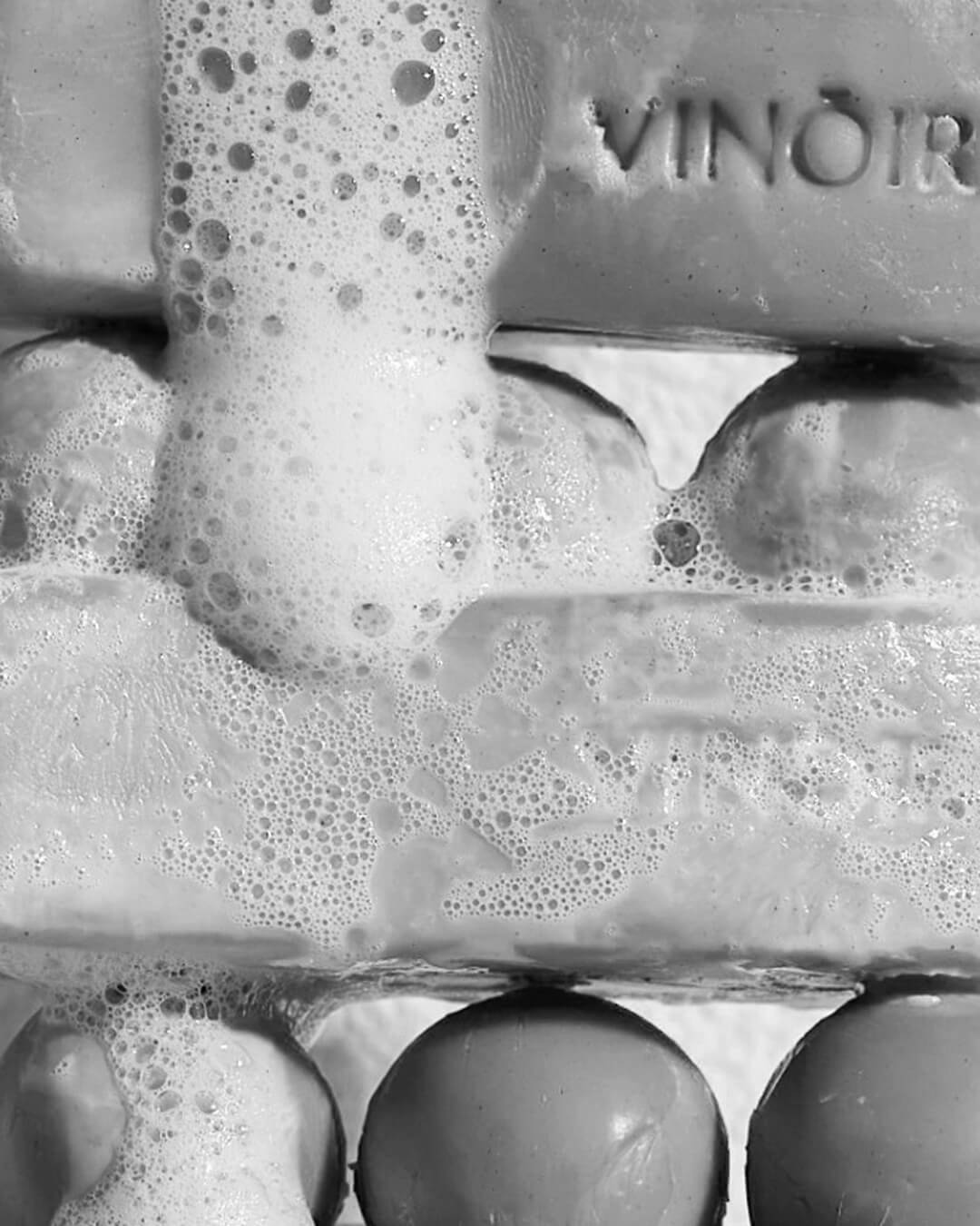 Ohlolly Korean Skincare Vinoir Decanting Shampoo Bar | Le Pique-Nique. Black and white photo of closeup of bar soaps and bubbles.