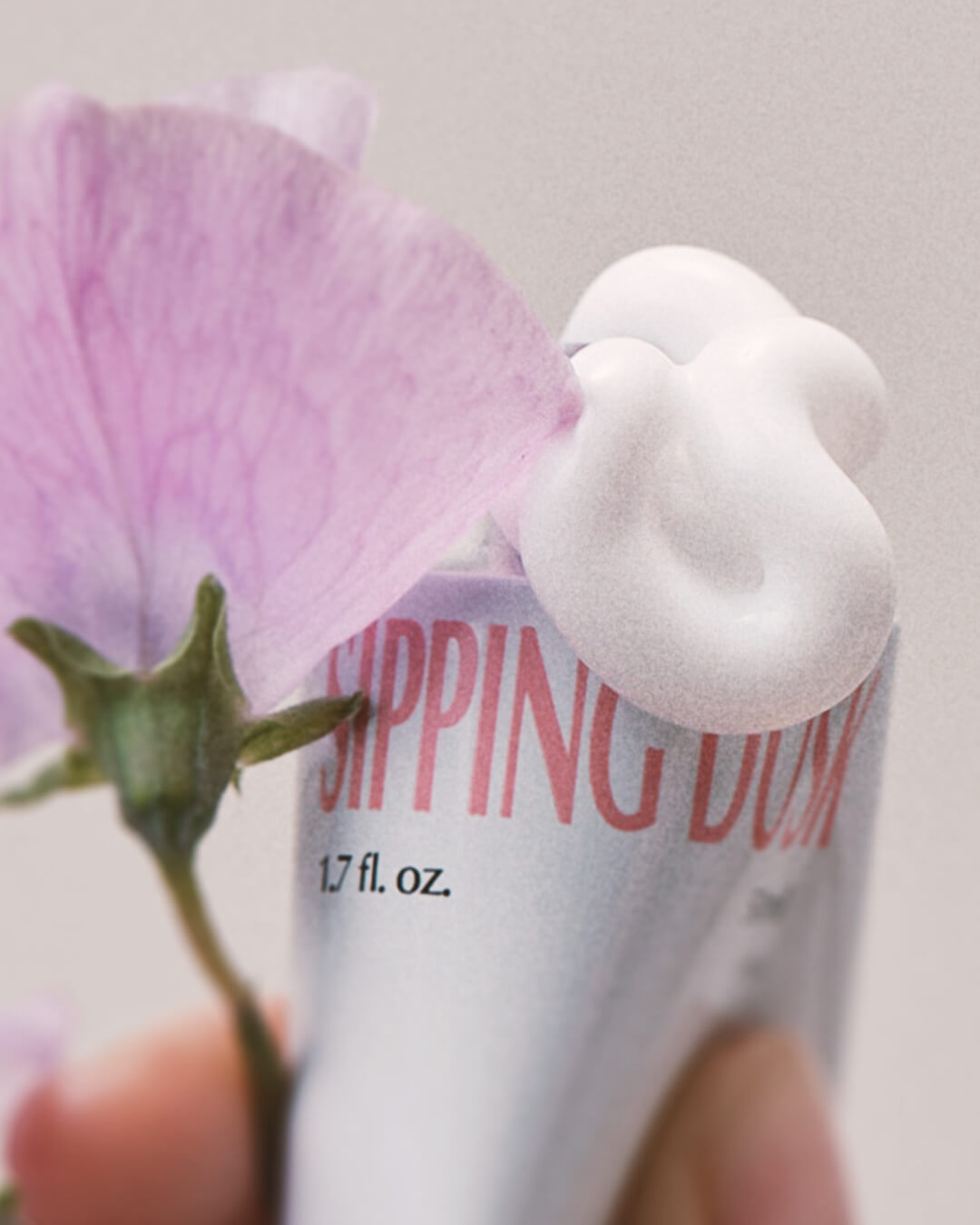 Ohlolly Korean Skincare Vinoir Decanting Hand Cream | Sipping Dusk. Scented moisturizer for dry hands. Texture squeezed out of tube. Flower. Closeup.