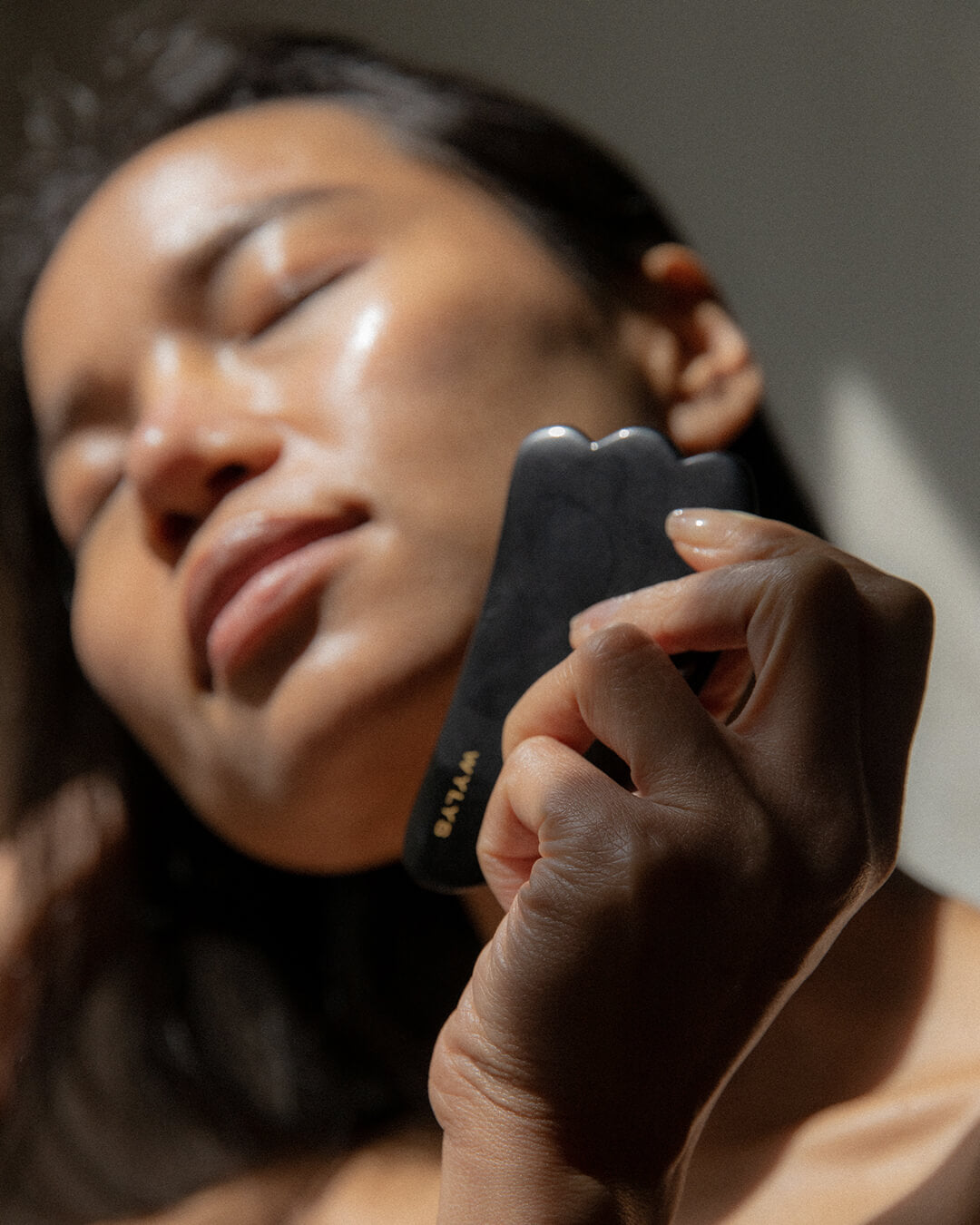 WYLYS Black Obsidian Gua Sha on Face. Depuff, sculpt, relax, made with 100% natural black obsidian. Model demo.