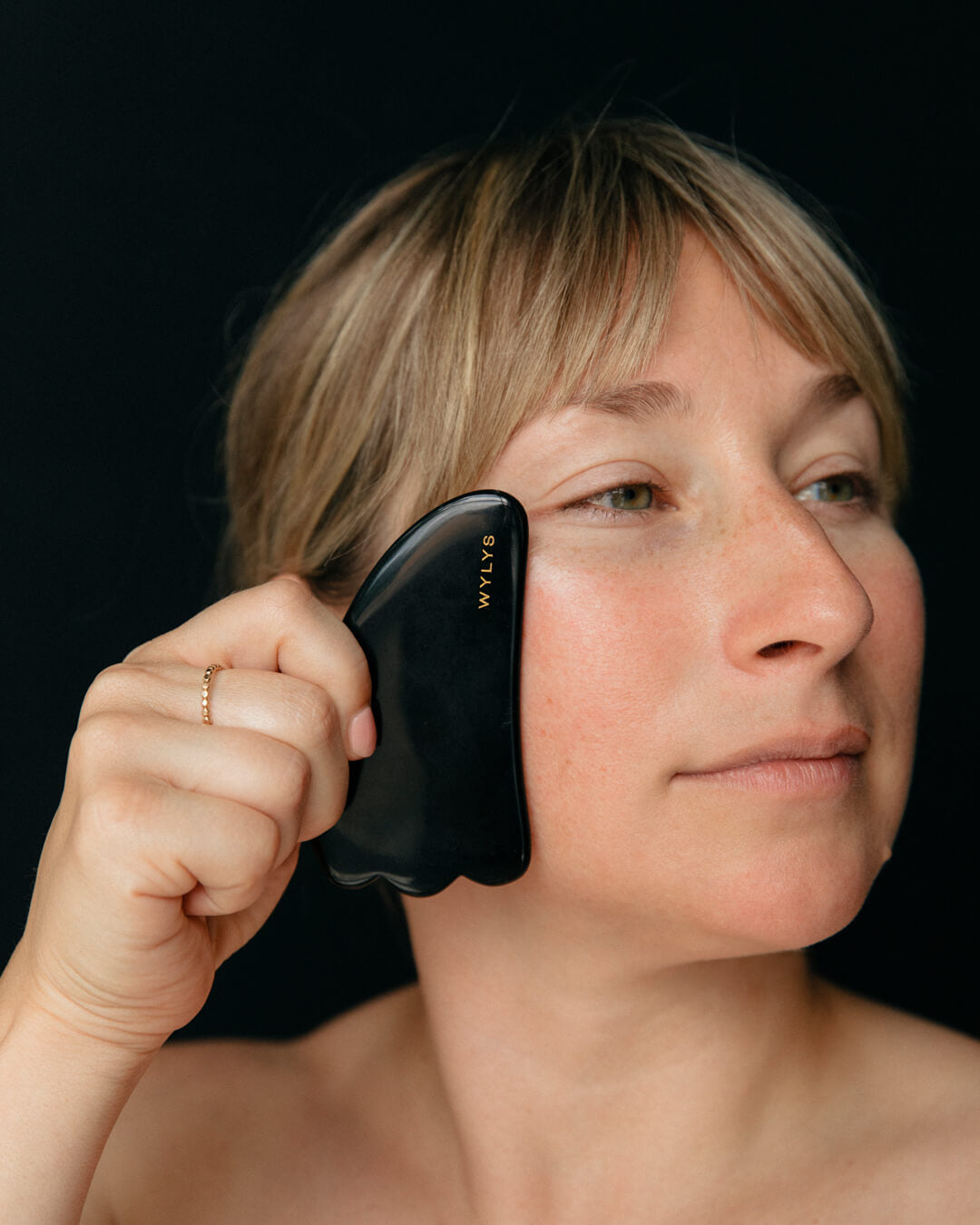 Ohlolly Korean Skincare Online Shop Wylys Black Obsidian Gua Sha + Face Roller Set, 100% natural Sculpting and depuffing tools for facial massage, tension relief, and radiant skin. Gua Sha on Model's face. Demo.